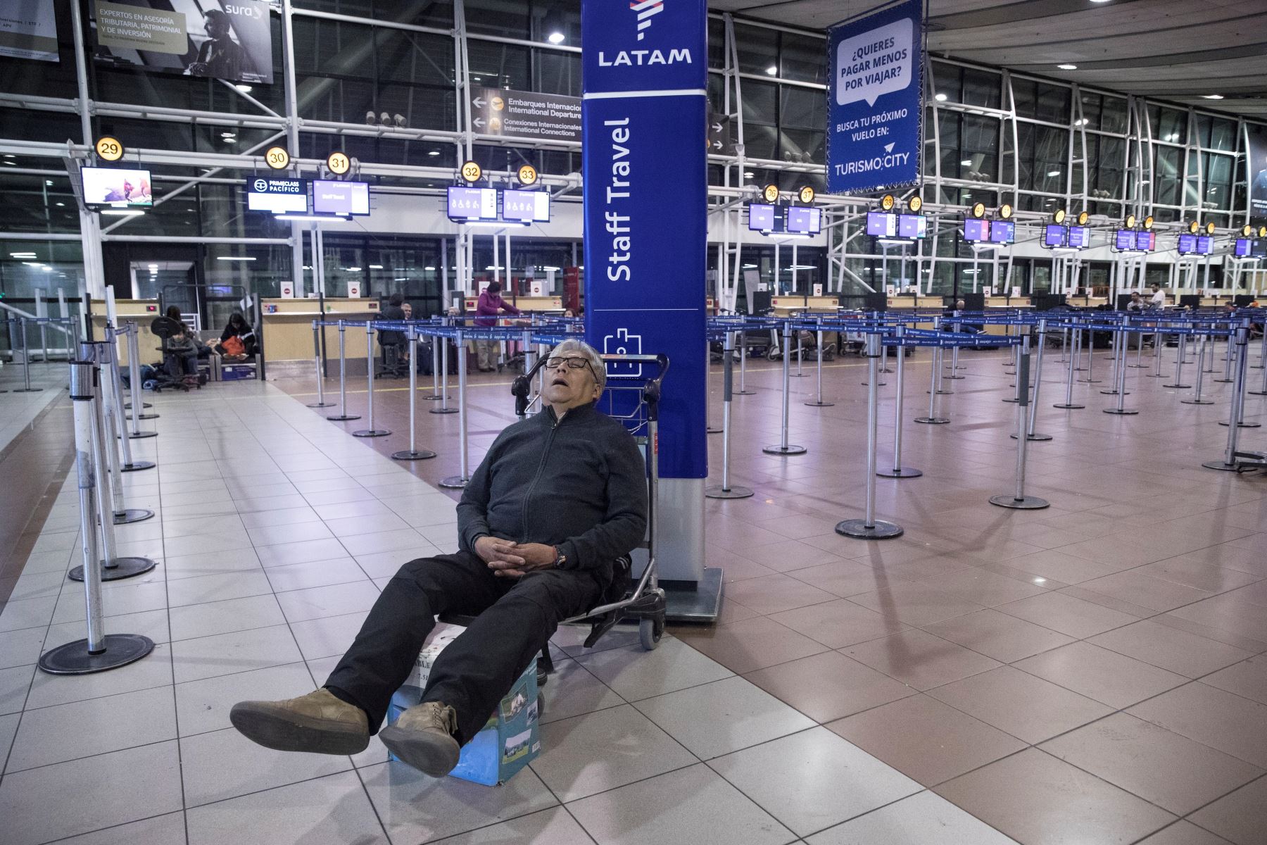 Un hombre descansa mientras cientos de pasajeros quedaron en la noche de este domingo y la madrugada del lunes atrapados en el aeropuerto de Santiago de Chile. Foto: EFE