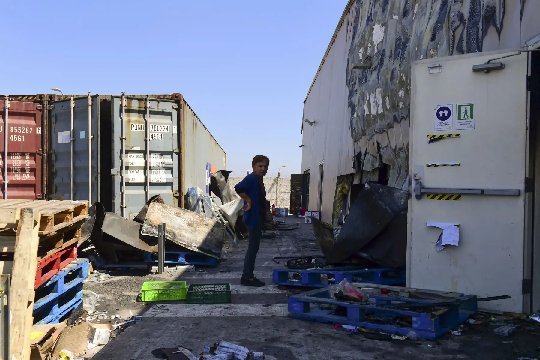 Una mujer se para afuera de un supermercado quemado y saqueado en Santiago, Chile. Foto: AFP