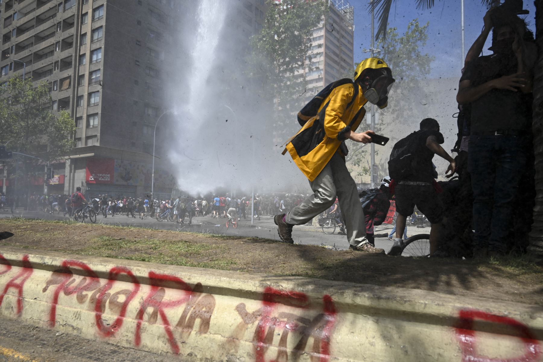 Policía antidisturbios dispara cañones de agua para dispersar a los manifestantes en el quinto día consecutivo de protestas contra un aumento ahora suspendido en los precios de los boletos del metro, en Santiago, Chile. Foto: AFP