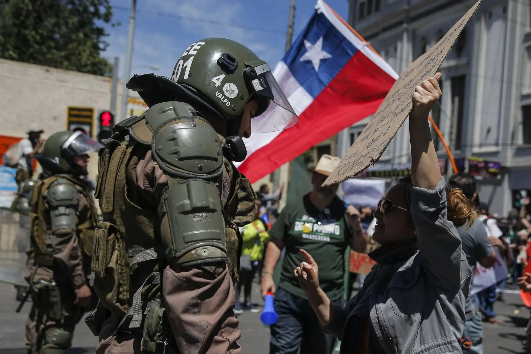 Una manifestante dialoga con un policía antidisturbios en Valparaíso en el quinto día consecutivo de protestas contra una subida ahora suspendida en los precios de los boletos del metro. Foto: AFP