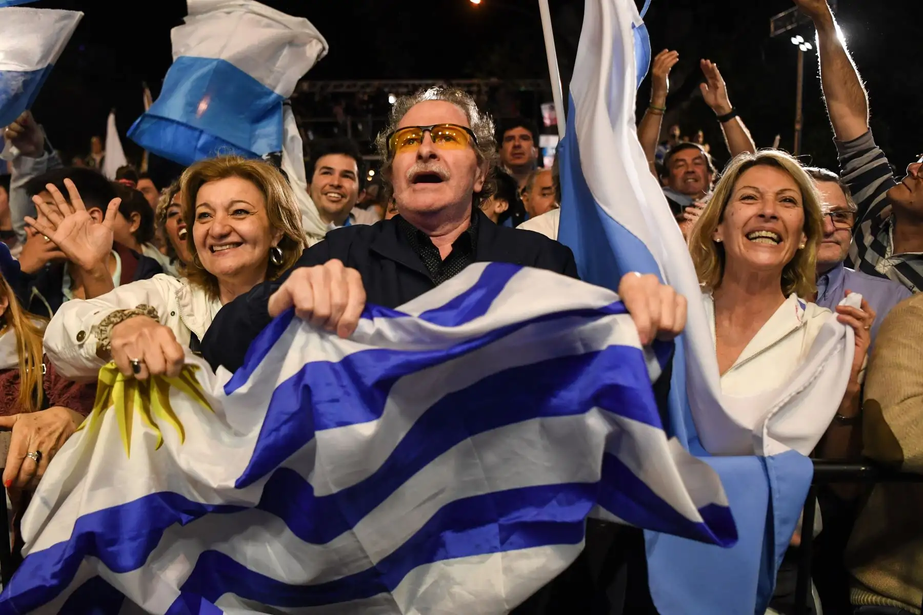 Los partidarios del candidato presidencial para el partido Partido Nacional de Uruguay, Luis Lacalle Pou, aplauden fuera de la sede del partido en Montevideo después de que cerraron las urnas en las elecciones generales .Foto:AFP