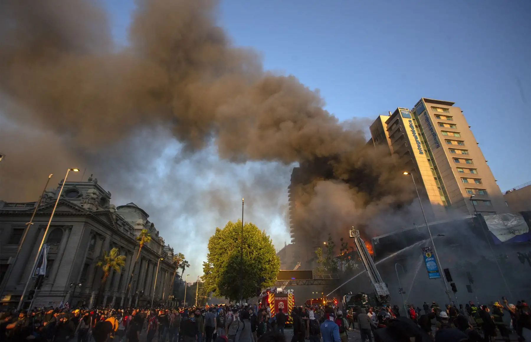 Los bomberos combaten un incendio en un edificio en Santiago momentos después de manifestaciones y protestas callejeras que han dejado al menos 20 personas muertas.Foto:AFP