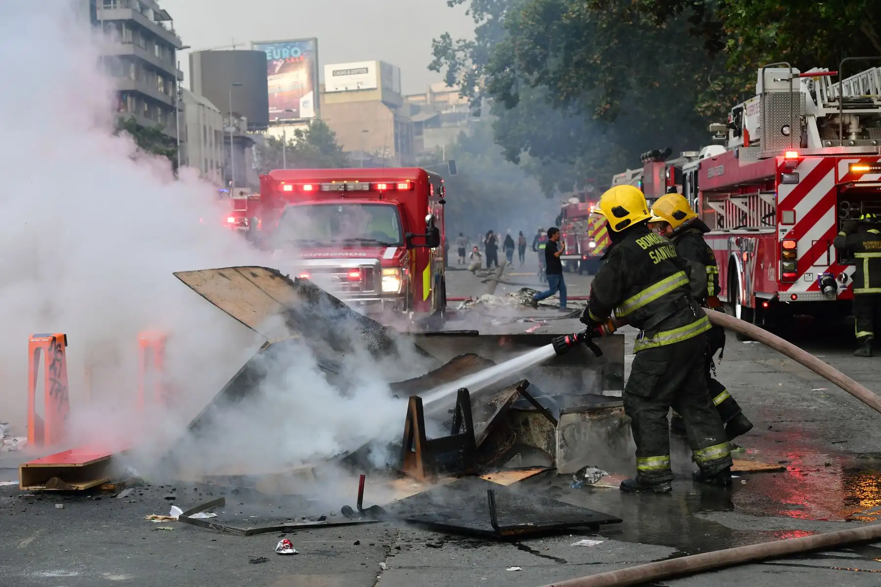 Los bomberos apagaron una hoguera en una barricada durante las protestas contra las políticas económicas del gobierno en el centro de Santiago de Chile. Foto:AFP