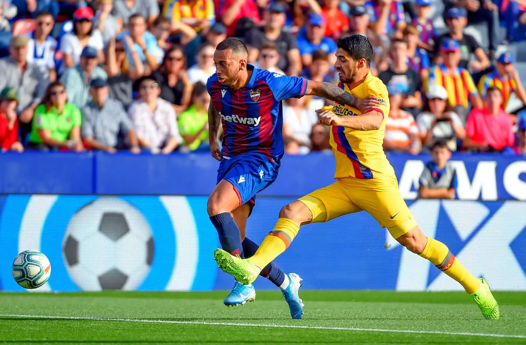 El defensor portugués del Levante, Rubén Vezo,  compite con el delantero uruguayo de Barcelona, Luis Suárez, durante el partido de fútbol de la Liga española. Foto: AFP