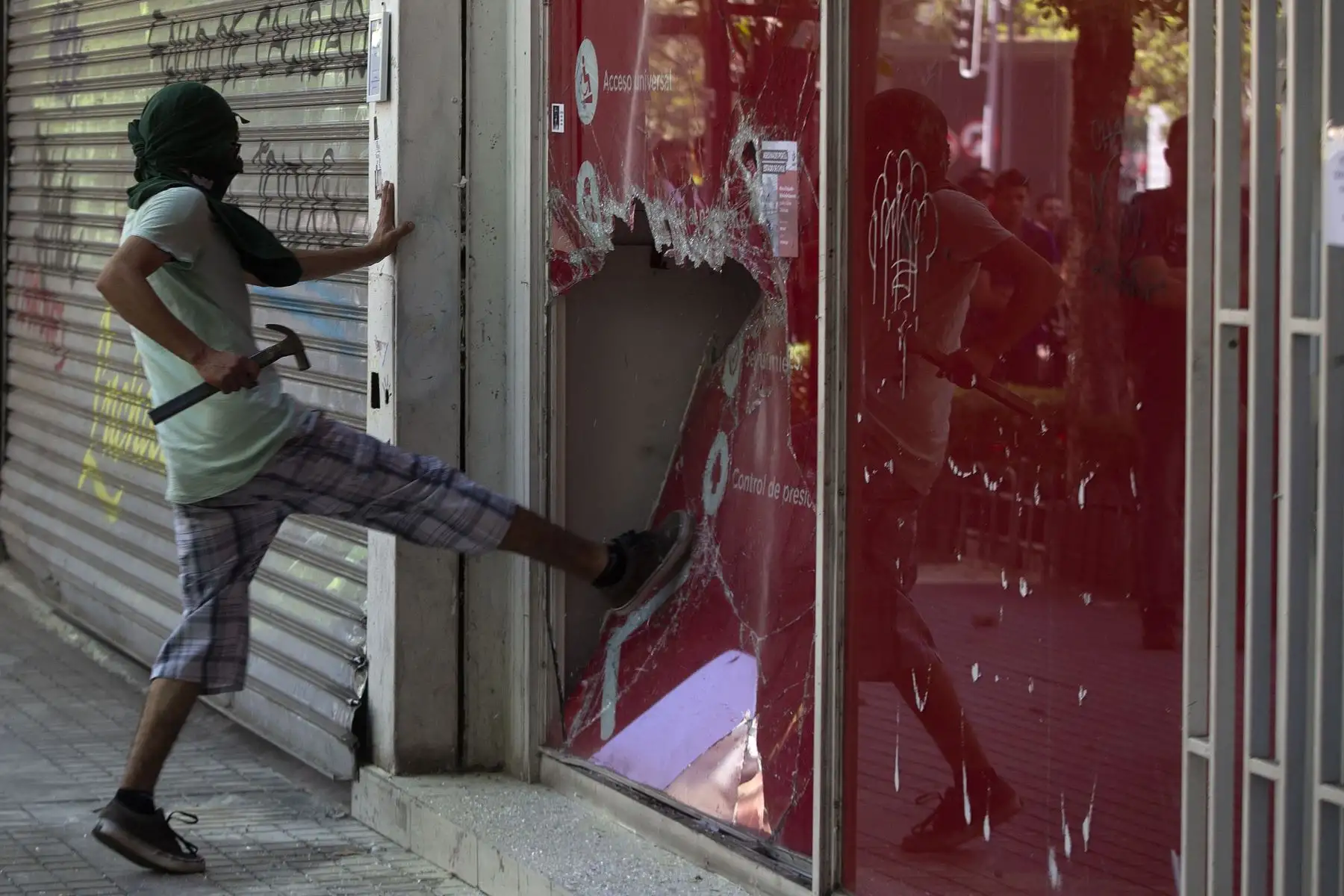 Un manifestante rompe una ventana durante una protesta contra las políticas económicas del gobierno en Chile en Santiago.
Foto:AFP