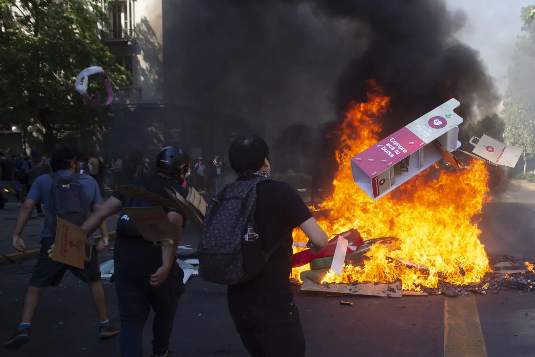Los manifestantes arrojan cartón para quemar en una hoguera durante una protesta contra las políticas económicas del gobierno en Santiago.
Foto: AFP