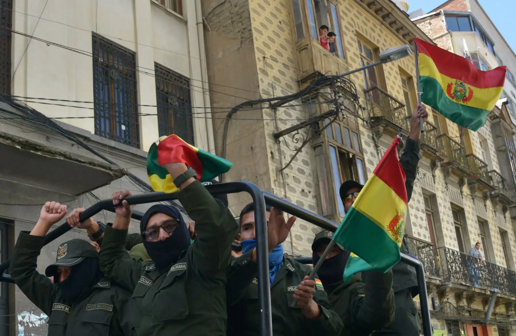 Los oficiales de la Unidad Táctica de Operaciones Especiales de la Policía (UTOP) que exhiben banderas bolivianas se dirigen a su cuartel general en la Plaza de Armas en La Paz. 
Después de anunciar que se unirían a una rebelión contra el presidente Evo Morales lanzada en la víspera por otras unidades.
Foto: AFP