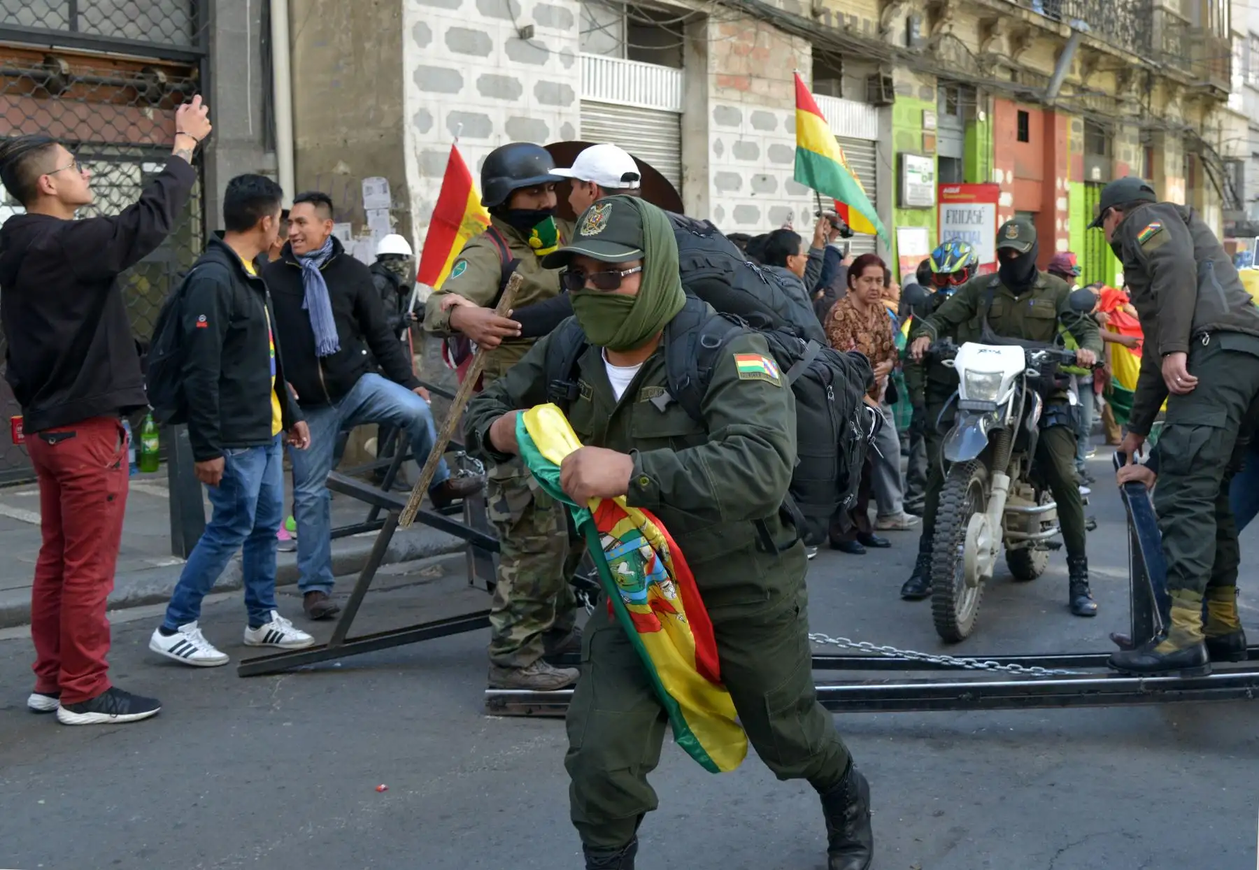 Los oficiales de la Unidad Táctica de Operaciones Especiales de la Policía (UTOP) que exhiben banderas bolivianas se dirigen a su cuartel general en la Plaza de Armas en La Paz. 
Después de anunciar que se unirían a una rebelión contra el presidente Evo Morales lanzada en la víspera por otras unidades.
Foto: AFP