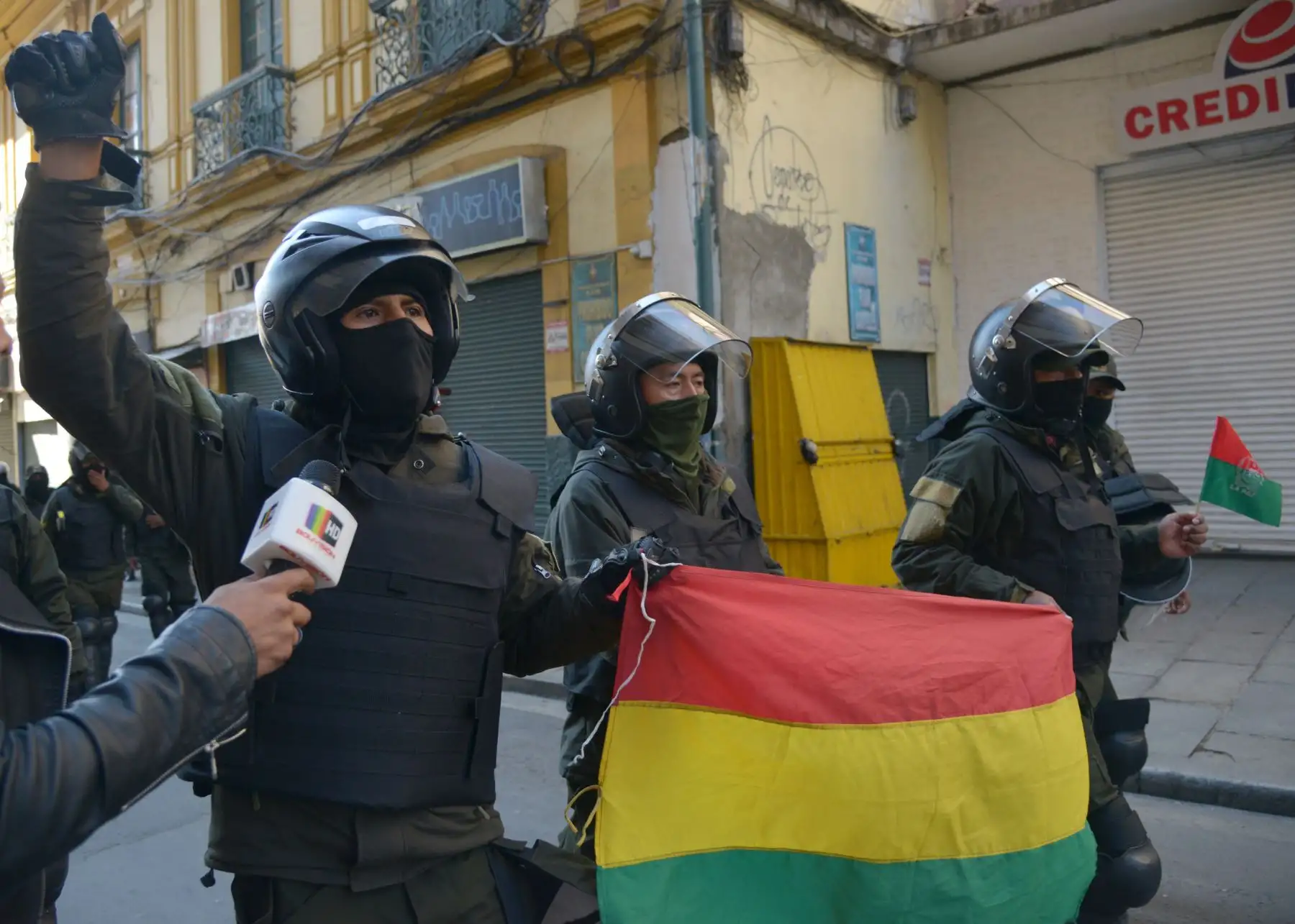 Los oficiales de la Unidad Táctica de Operaciones Especiales de la Policía (UTOP) que exhiben banderas bolivianas se dirigen a su cuartel general en la Plaza de Armas en La Paz. 
Después de anunciar que se unirían a una rebelión contra el presidente Evo Morales lanzada en la víspera por otras unidades.
Foto: AFP
