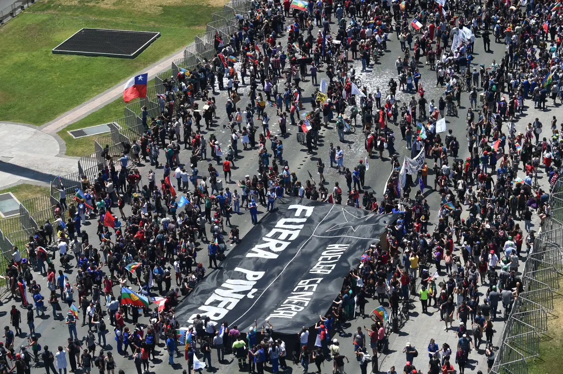 Vista aérea de personas marchando contra el gobierno del presidente chileno Sebastián Piñera con una pancarta que decía "Huelga general. Piña afuera" hacia el palacio presidencial de La Moneda en Santiago de Chile.
Foto: AFP