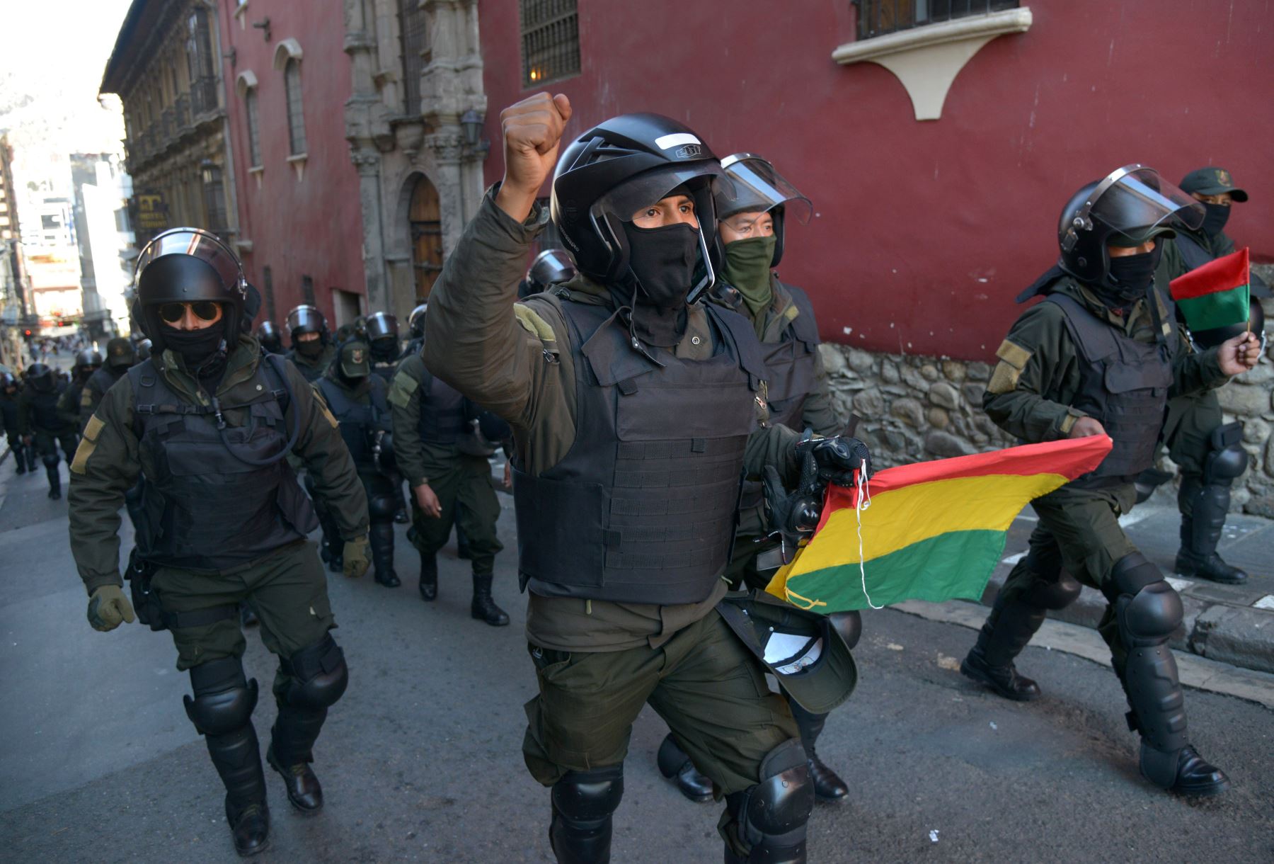 En esta imagen de archivo tomada el 9 de noviembre de 2019, oficiales de Bolivia muestran banderas dirigidas a su cuartel general en la Plaza de Armas en La Paz, después de anunciar que se unirían a una rebelión. Foto: AFP