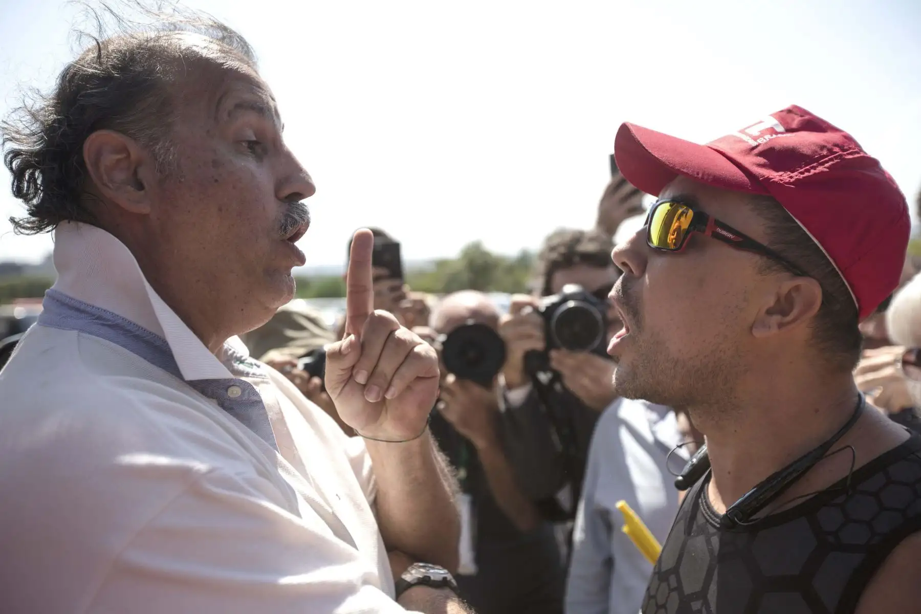 Un partidario de Nicolás Maduro, discute con un seguidor de Juan Guaidó, mientras seguidores de Guaidó permanecen en el interior en la embajada de Venezuela en Brasilia. Foto: EFE
