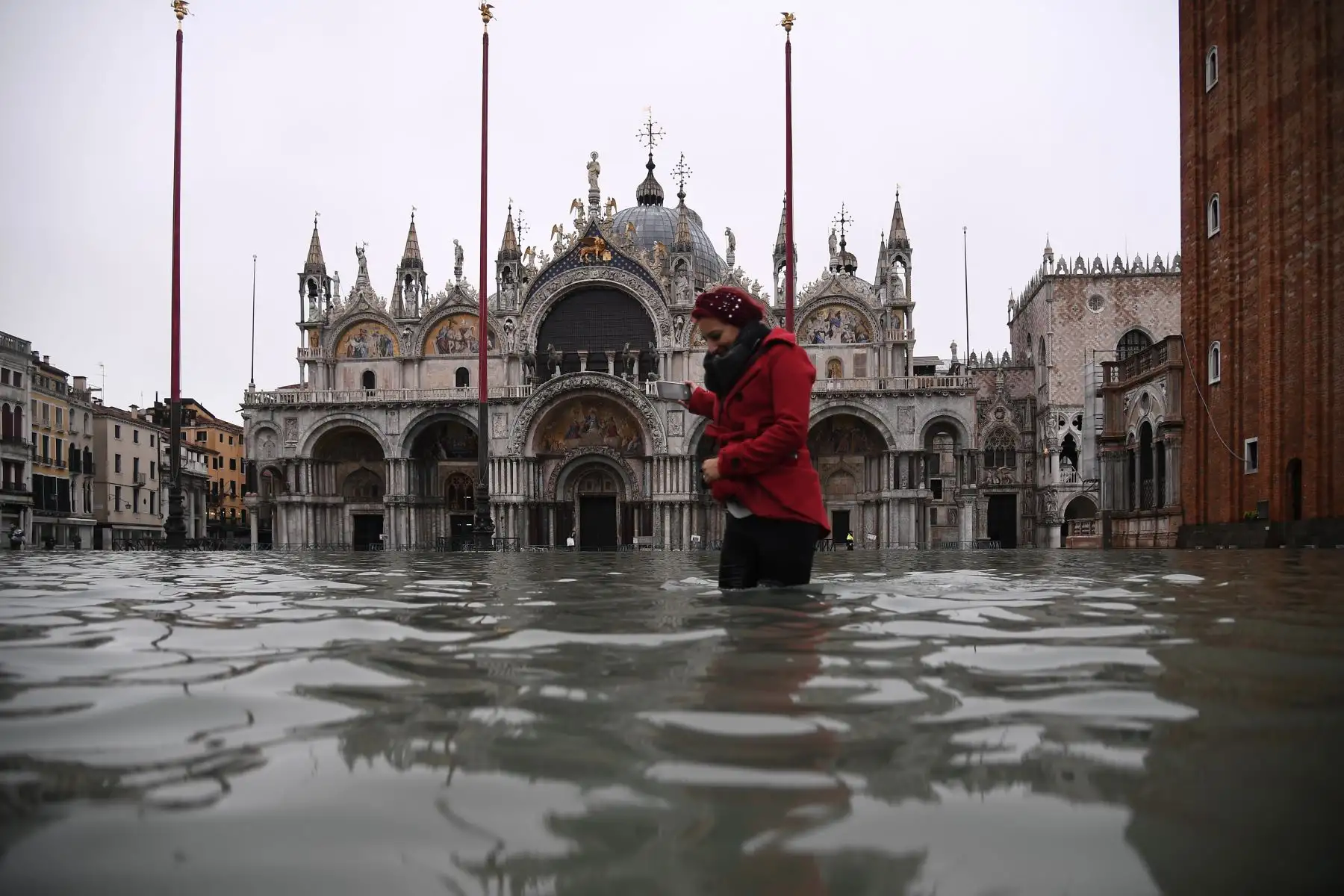 Una mujer cruza la inundada plaza de San Marcos junto a la basílica de San Marcos después de un excepcional nivel de agua durante la marea alta en Venecia.
Foto: AFP