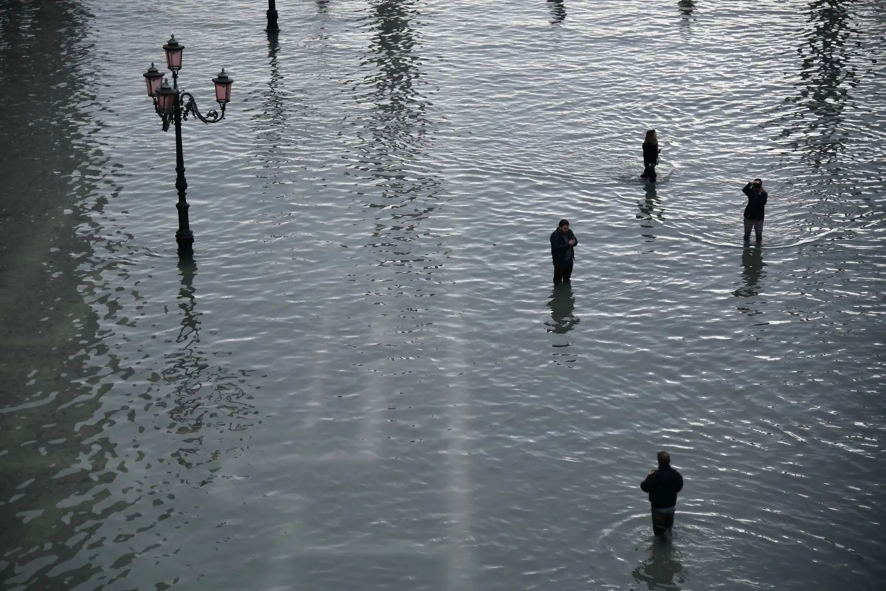 La gente camina y toma fotos en la inundada Plaza de San Marcos después de un excepcional nivel de agua durante la marea alta en Venecia.
Foto: AFP