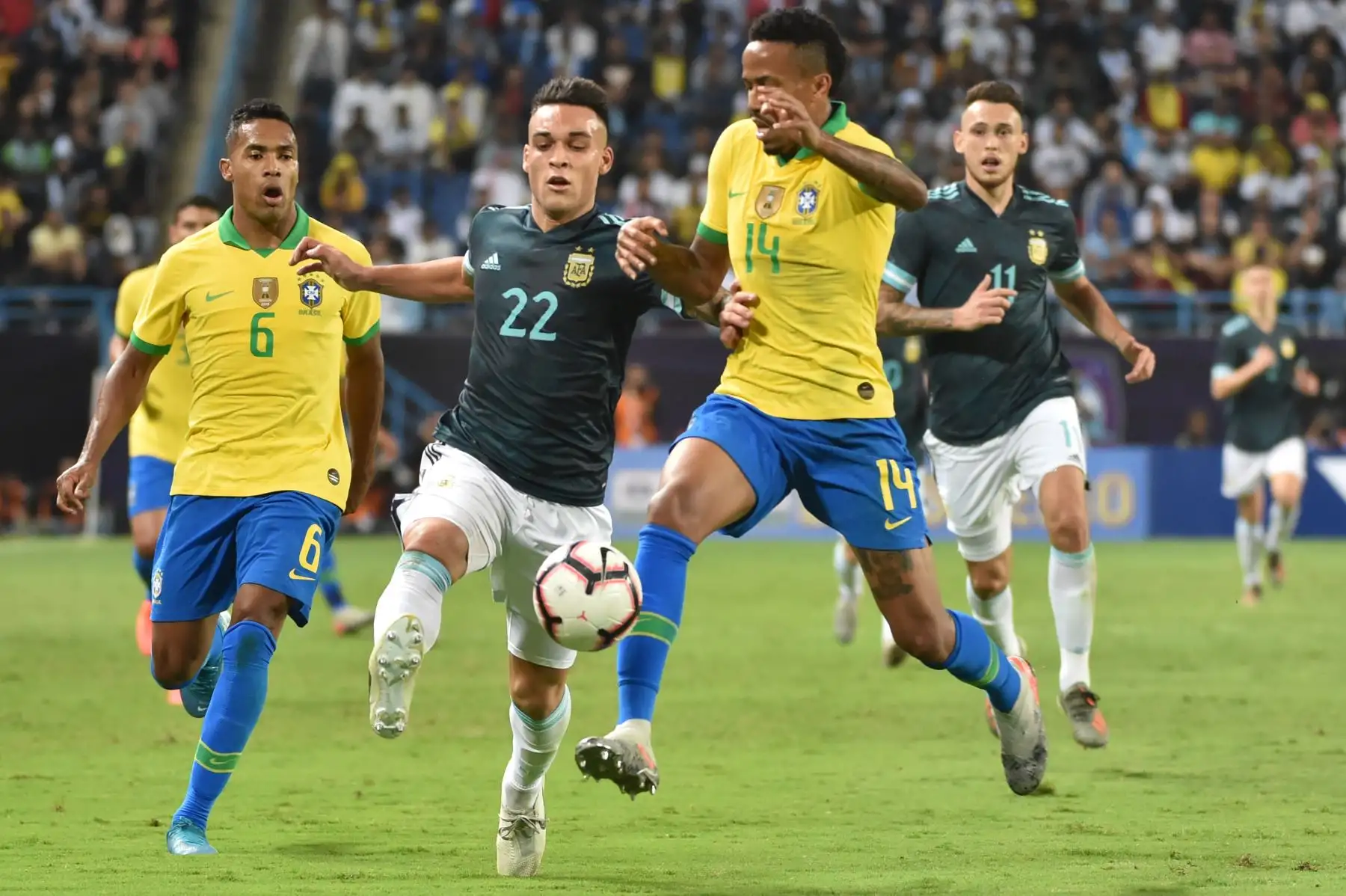 El delantero argentino Lautaro Martínez (C) está marcado por el defensor brasileño Eder Militao (R) durante el partido amistoso de fútbol entre Brasil y Argentina en el estadio de la Universidad King Saud en la capital saudita, Riad. AFP