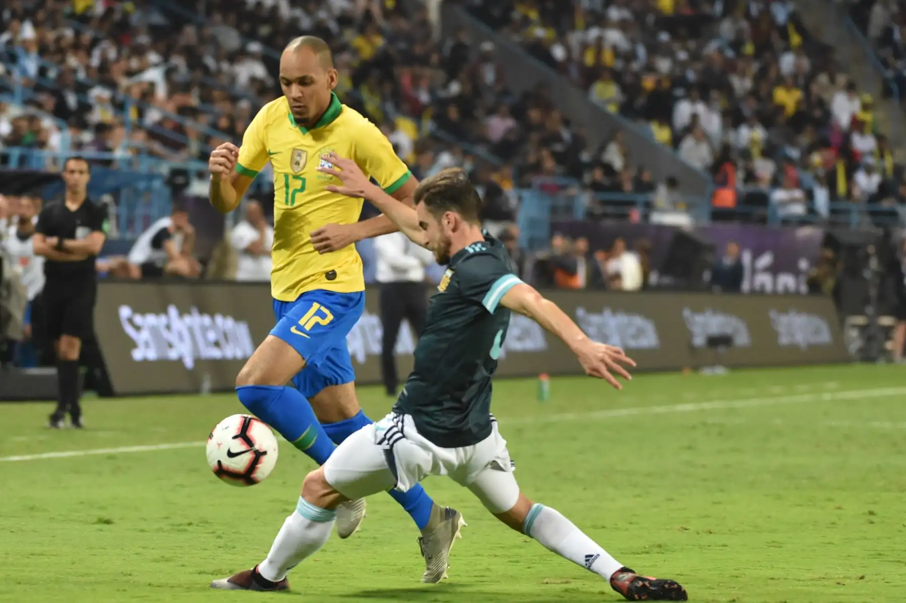 El mediocampista brasileño Fabinho (L) recibe una falta del defensor argentino Nicolas Tagliafico durante el partido amistoso de fútbol entre Brasil y Argentina.
 AFP