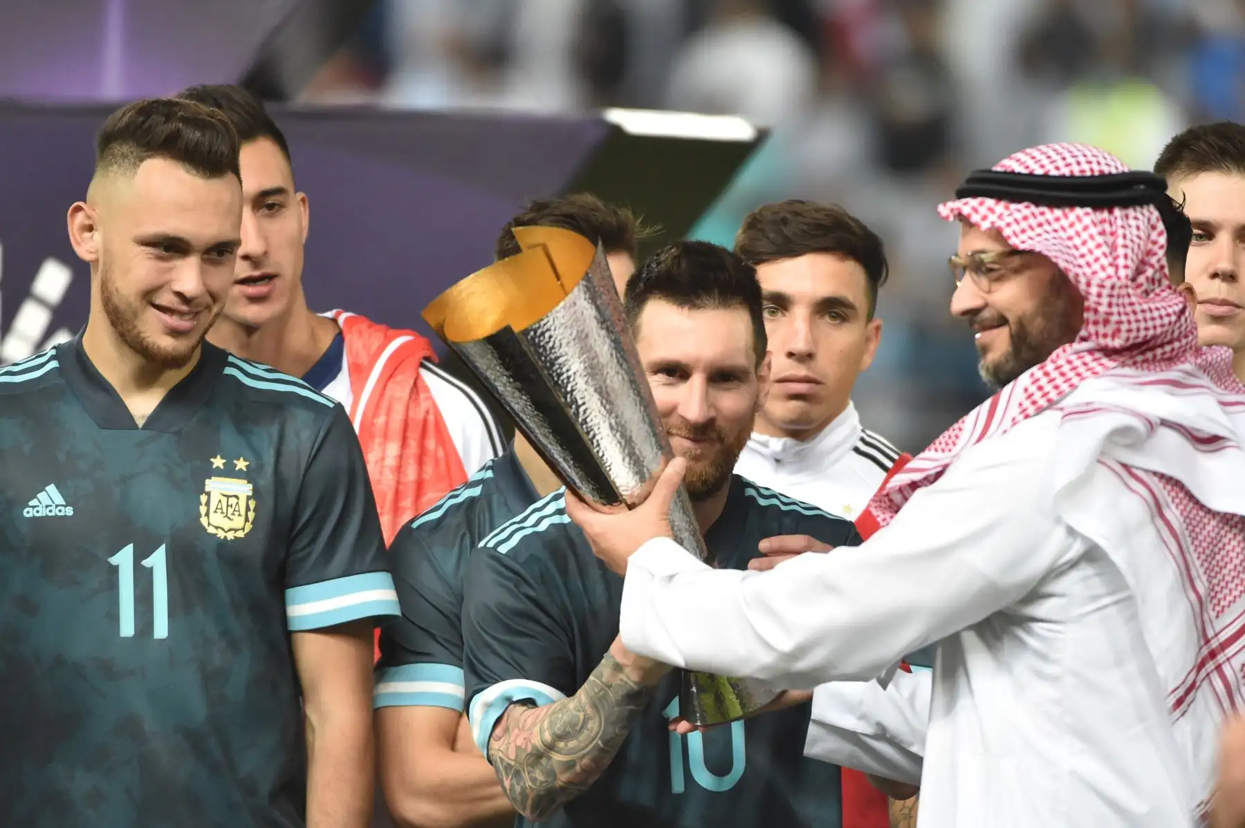El delantero argentino Lionel Messi recibe la copa después de su victoria durante el partido amistoso de fútbol entre Brasil y Argentina en el estadio de la Universidad King Saud en la capital saudita, Riad. AFP