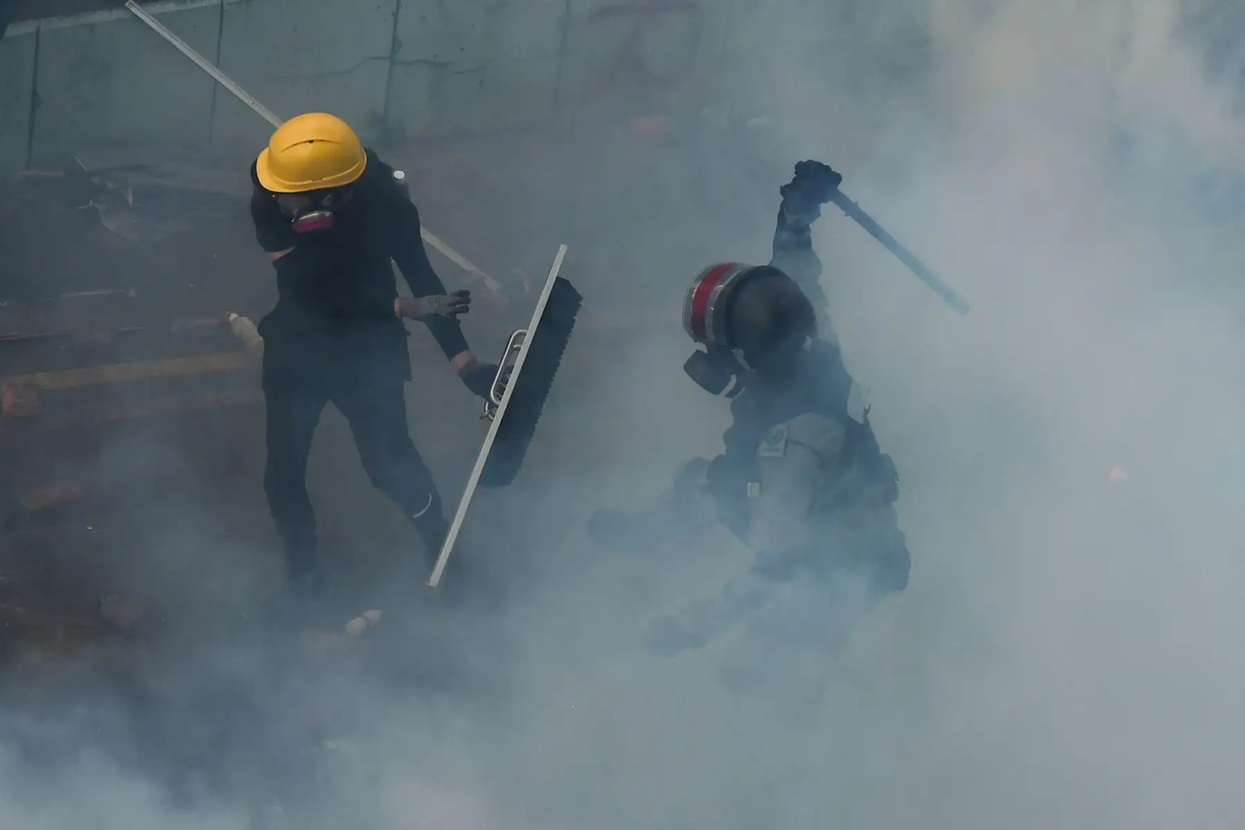 Los agentes trataron de desalojar el túnel, pero los manifestantes se refugiaron tras paraguas (uno de los símbolos de la protesta) y prendieron fuego entre escombros, lo que generó pequeñas explosiones.Foto: AFP