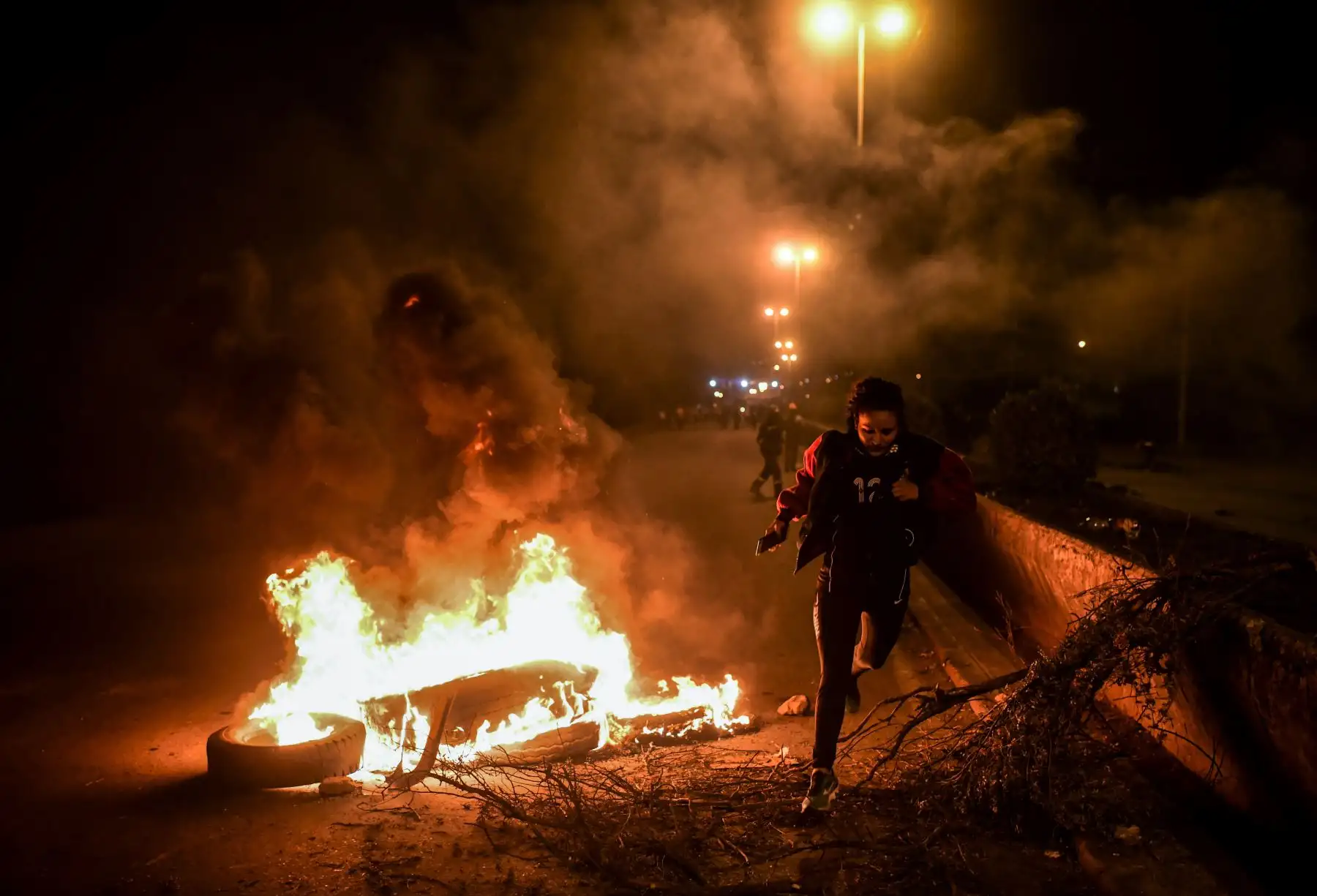 Una mujer cruza un bloqueo contra incendios establecido por partidarios del ex presidente boliviano Evo Morales en las afueras de Sacaba, provincia de Chapare, Cochabamba. Foto: AFP