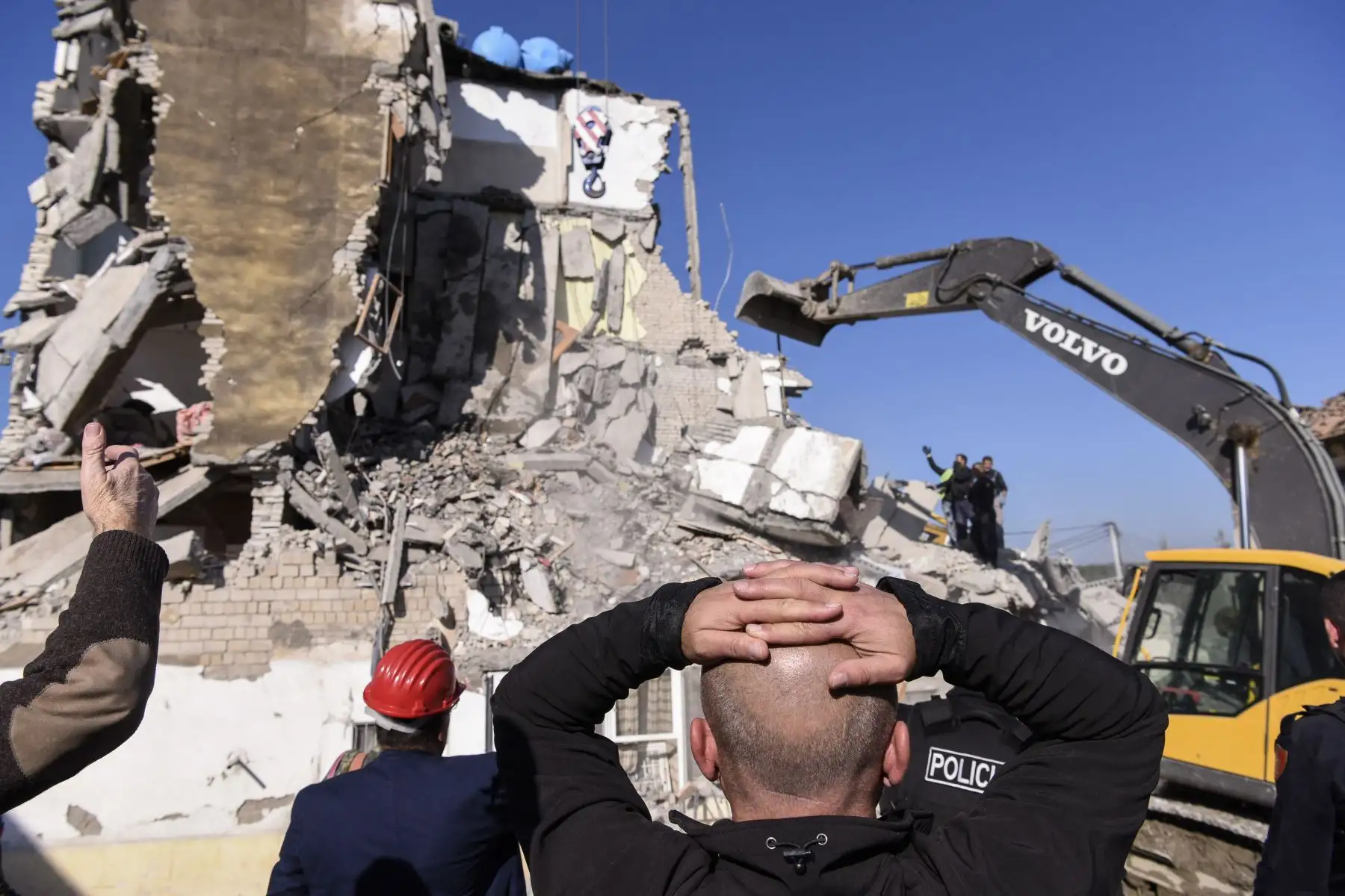 Los trabajadores de emergencia limpian escombros en un edificio dañado en Thumane, 34 kilómetros al noroeste de la capital, Tirana en Albania. Foto: AFP