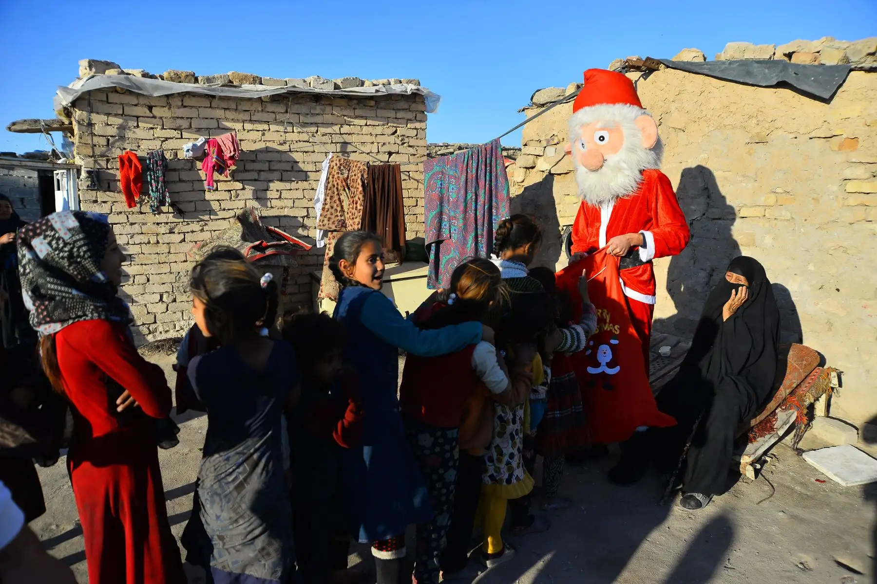 Un hombre vestido como Santa Claus distribuye regalos en Najaf. Foto: AFP