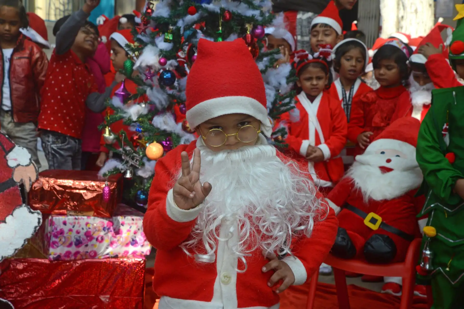 Niños de la escuela junto con maestros disfrazados de Santa Claus participan en un evento navideño en la India. Foto: AFP