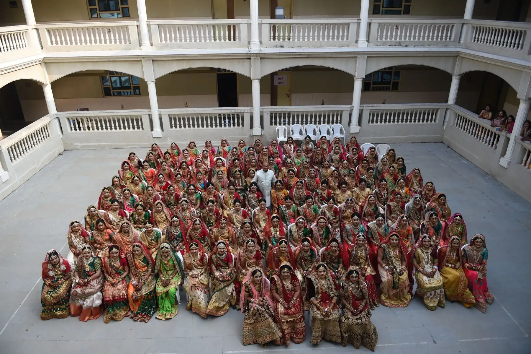 El empresario indio Maheshbhai Savani  posa con unas 135 novias durante una ceremonia de boda masiva en Surat, a unos 270 km de Ahmedabad - India.
Foto: AFP
