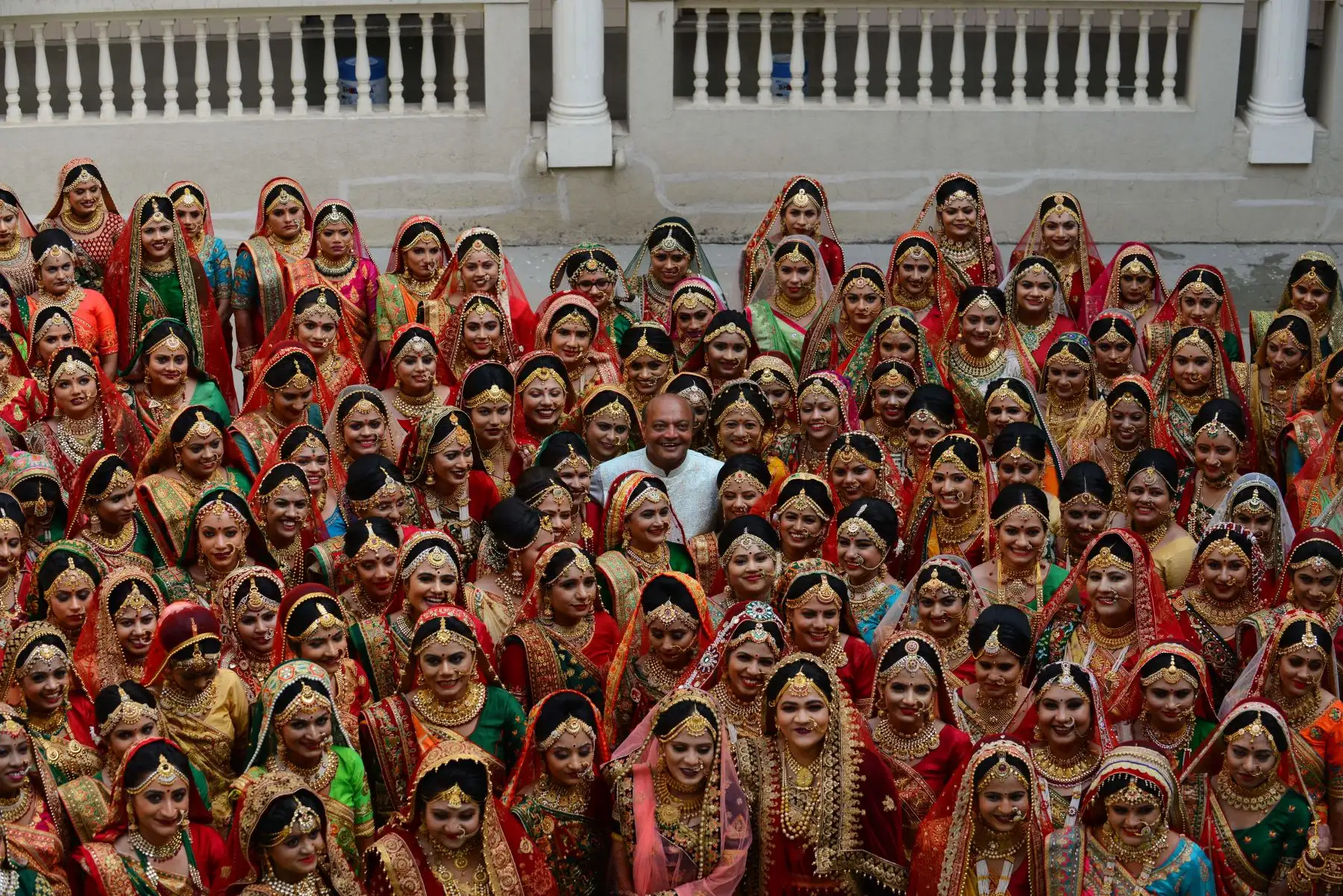El empresario indio Maheshbhai Savani (C) posa con unas 135 novias durante una ceremonia de boda masiva en Surat, a unos 270 km de Ahmedabad - India.
Foto: AFP