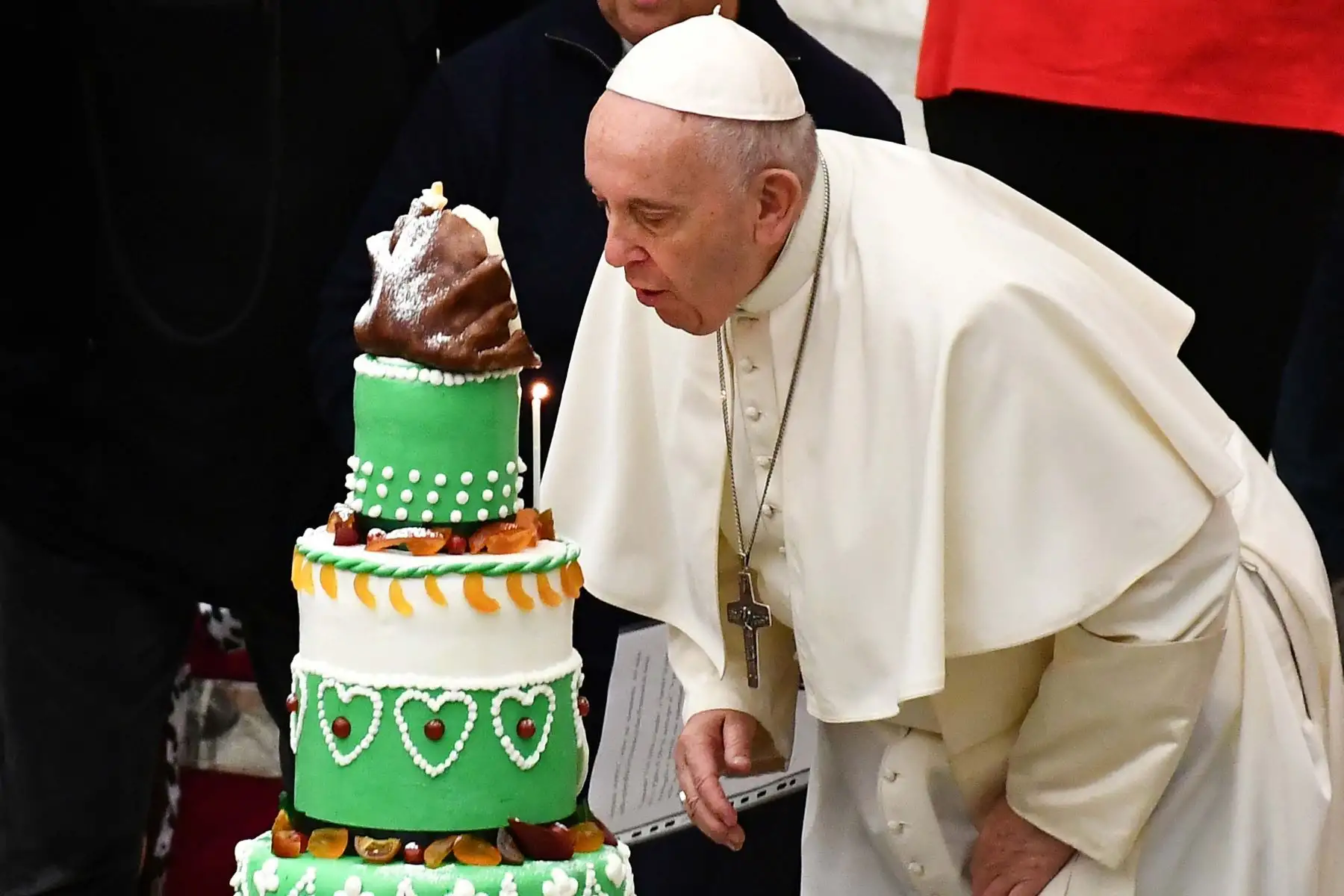 El Papa Francisco sopla velas de un pastel de cumpleaños que se le presentó por su 83 cumpleaños durante una audiencia para niños y familias del dispensario de Santa Marta en el Vaticano.
Foto: AFP