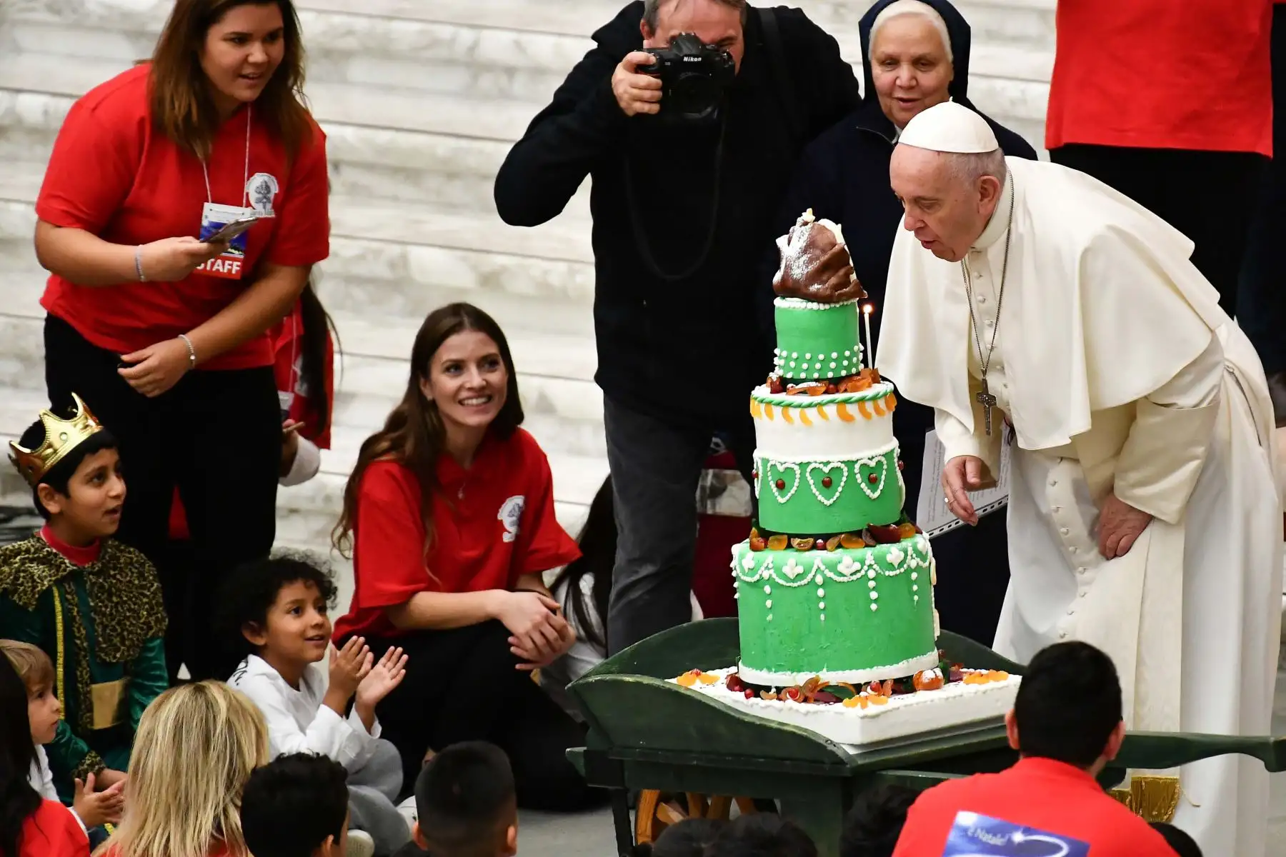 El Papa Francisco sopla velas de un pastel de cumpleaños que se le presentó por su 83 cumpleaños durante una audiencia para niños y familias del dispensario de Santa Marta en el Vaticano.
Foto: AFP