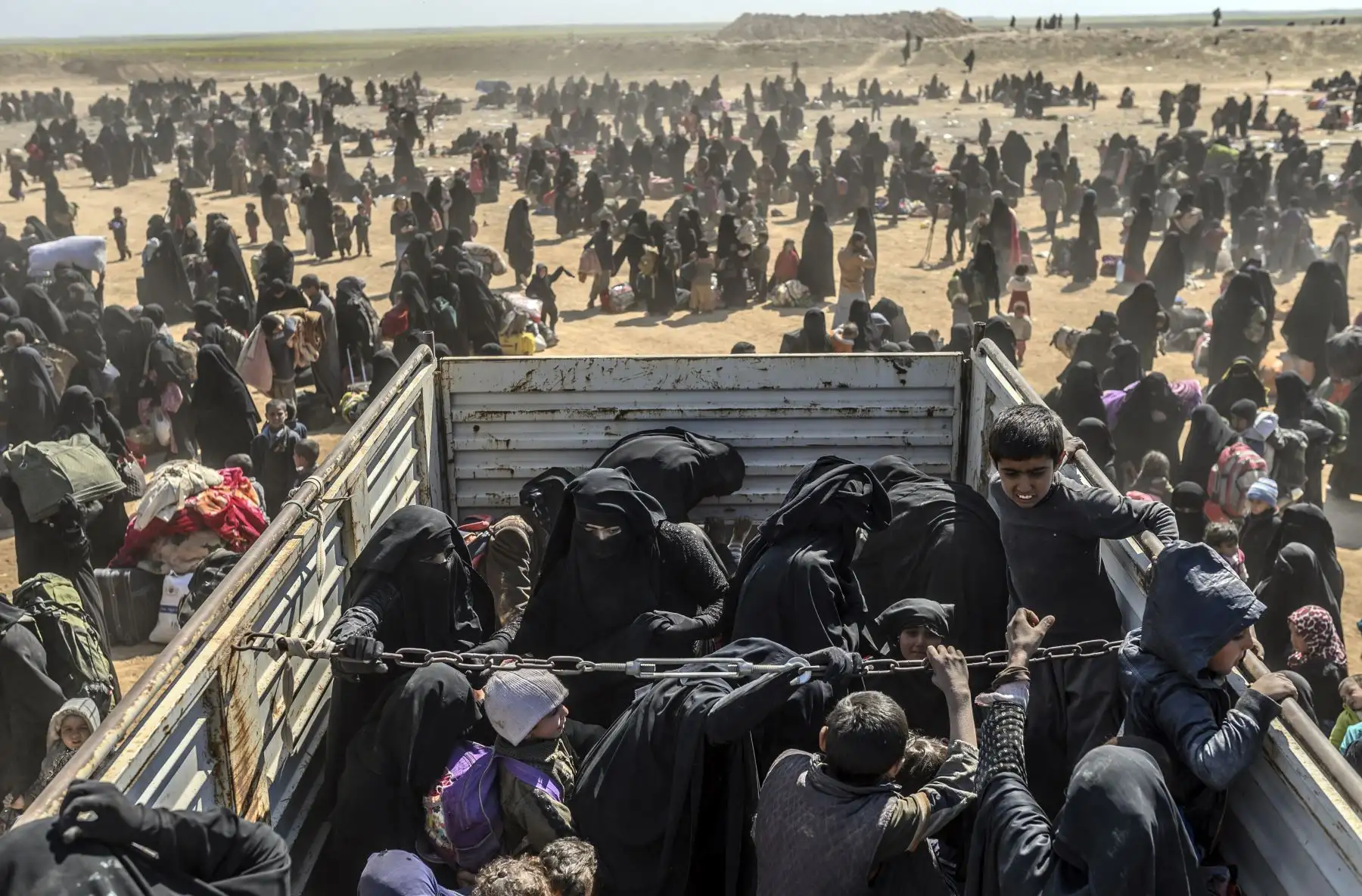 Mujeres y niños son evacuados del asedio de Baghouz por el grupo del Estado Islámico (EI) llegan a una zona de inspección en Siria. Foto: AFP
