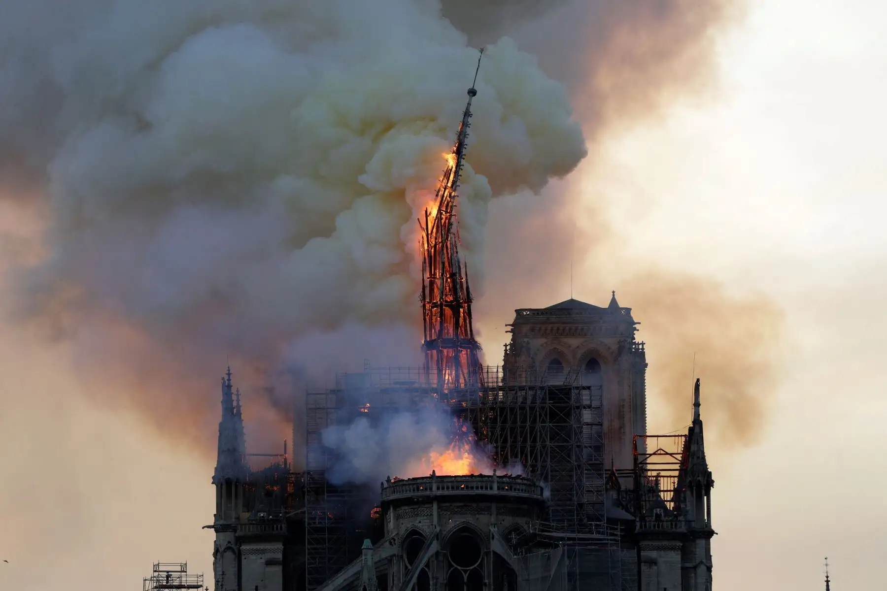 El campanario y la aguja de la emblemática Catedral de Notre-Dame se derrumban cuando la catedral se ve envuelta en llamas en el centro de París el 15 de abril de 2019.Foto: AFP
