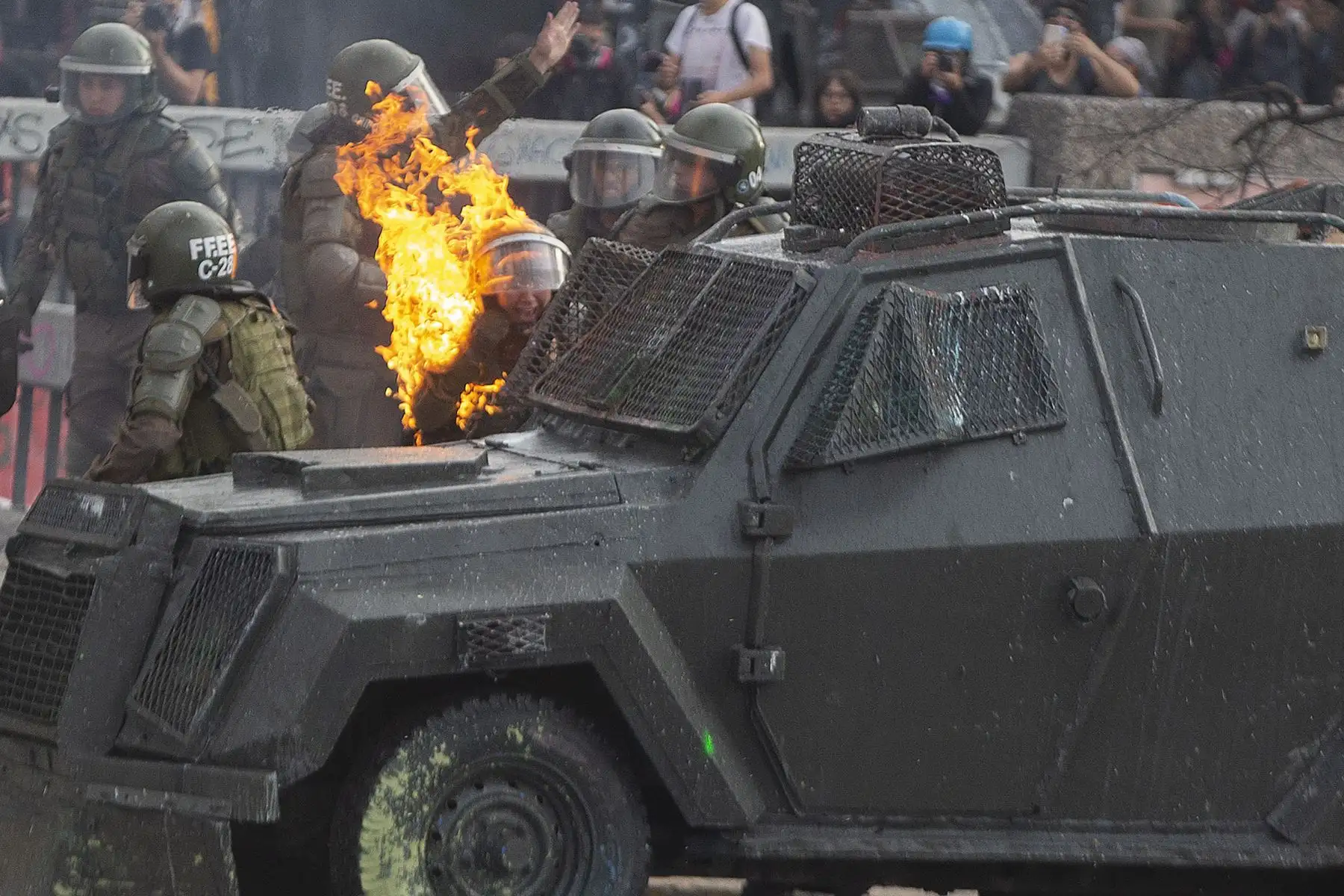 Una bomba de gasolina alcanza a la policía antidisturbios durante los enfrentamientos con manifestantes en Chile. Foto: AFP