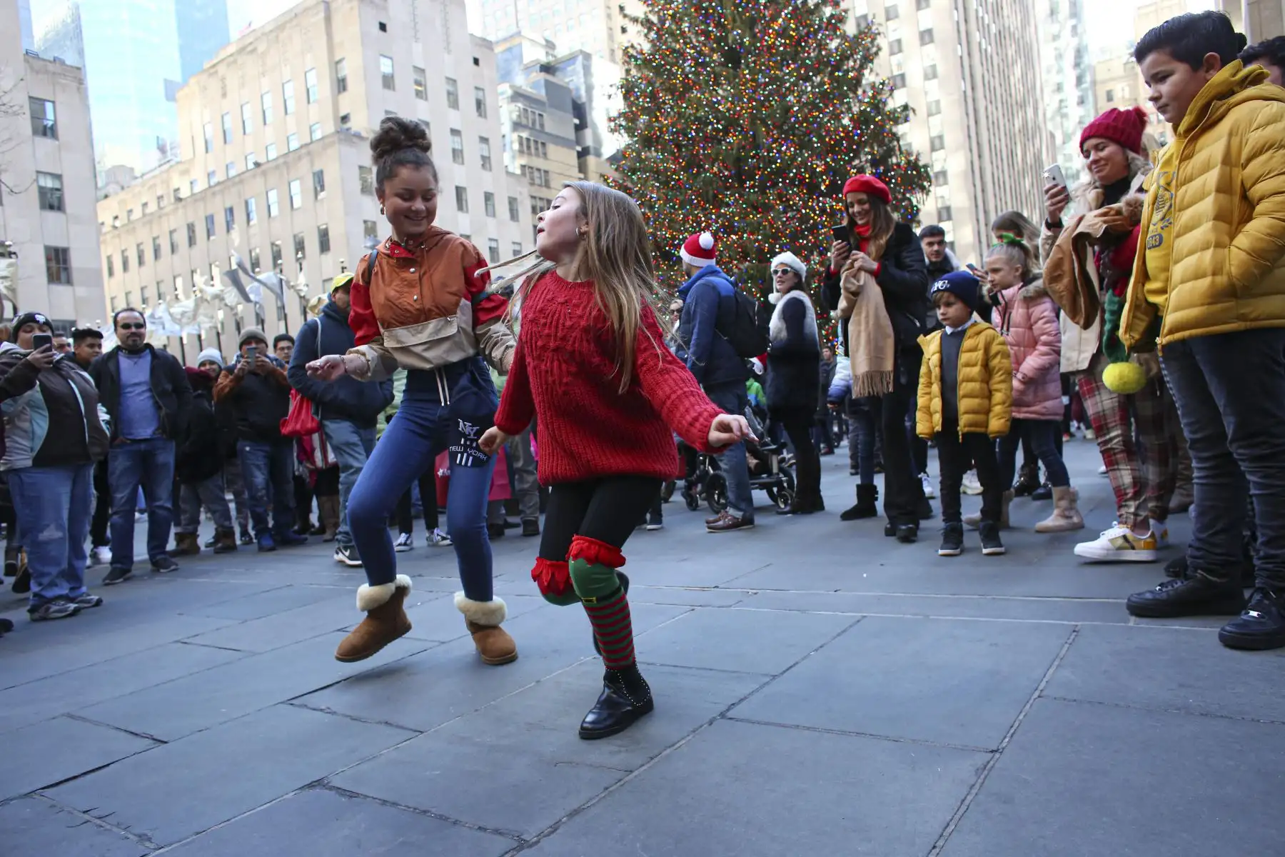 Las niñas bailan en el Rockefeller Center junto al árbol de Navidad en la ciudad de Nueva York.
Foto: AFP