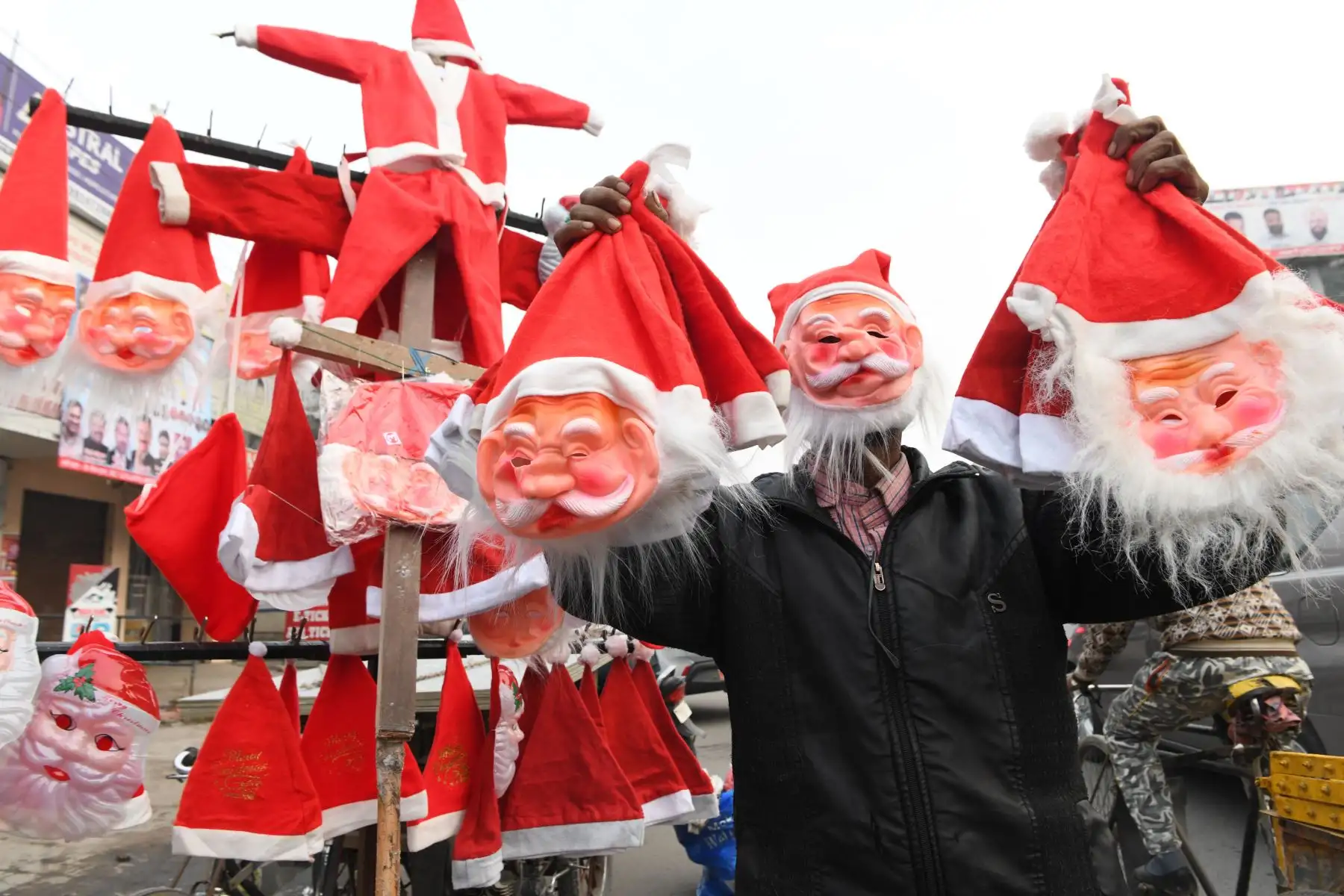 Un vendedor sostiene los sombreros y máscaras de Papá Noel que vendía en una carretera en Amritsar en la India.
Foto: AFP