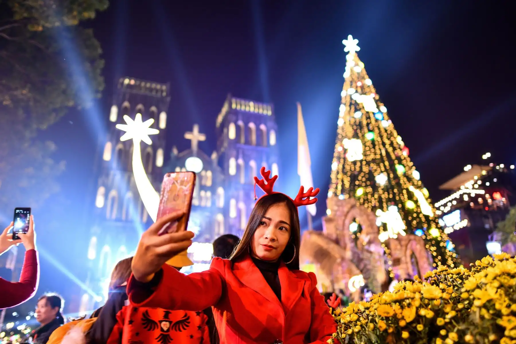 Una mujer se toma una selfie afuera de la catedral de San José de finales del siglo XIX en los barrios antiguos de Hanoi durante la víspera de Navidad.
Foto: AFP