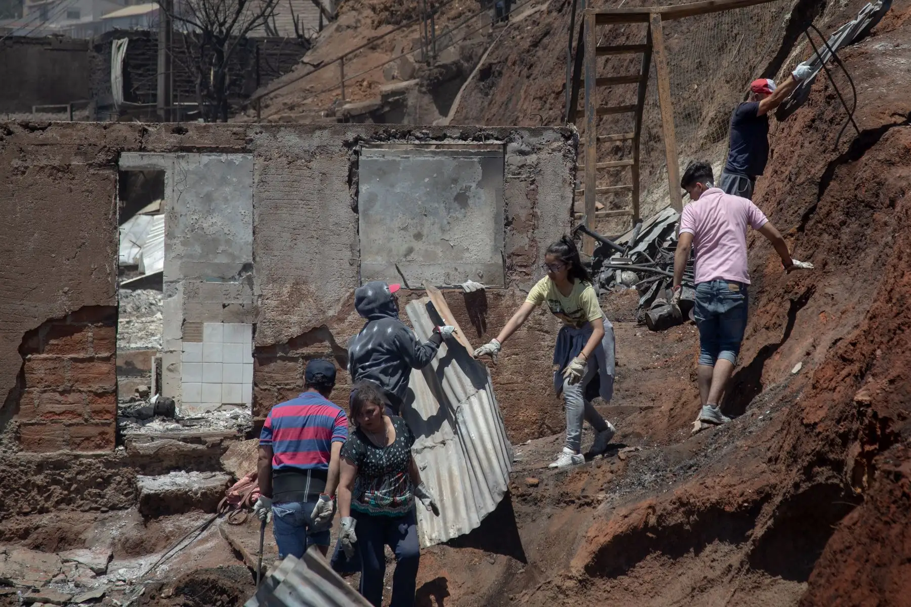 Los lugareños buscan pertenencias personales después de un incendio forestal en el cerro Rocuant en Valparaíso, Chile.
Foto: AFP