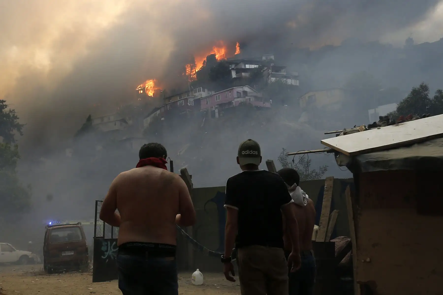 Los hombres miran casas incendiadas durante un incendio forestal en el cerro Rocuant en Valparaíso, Chile.
Foto: AFP