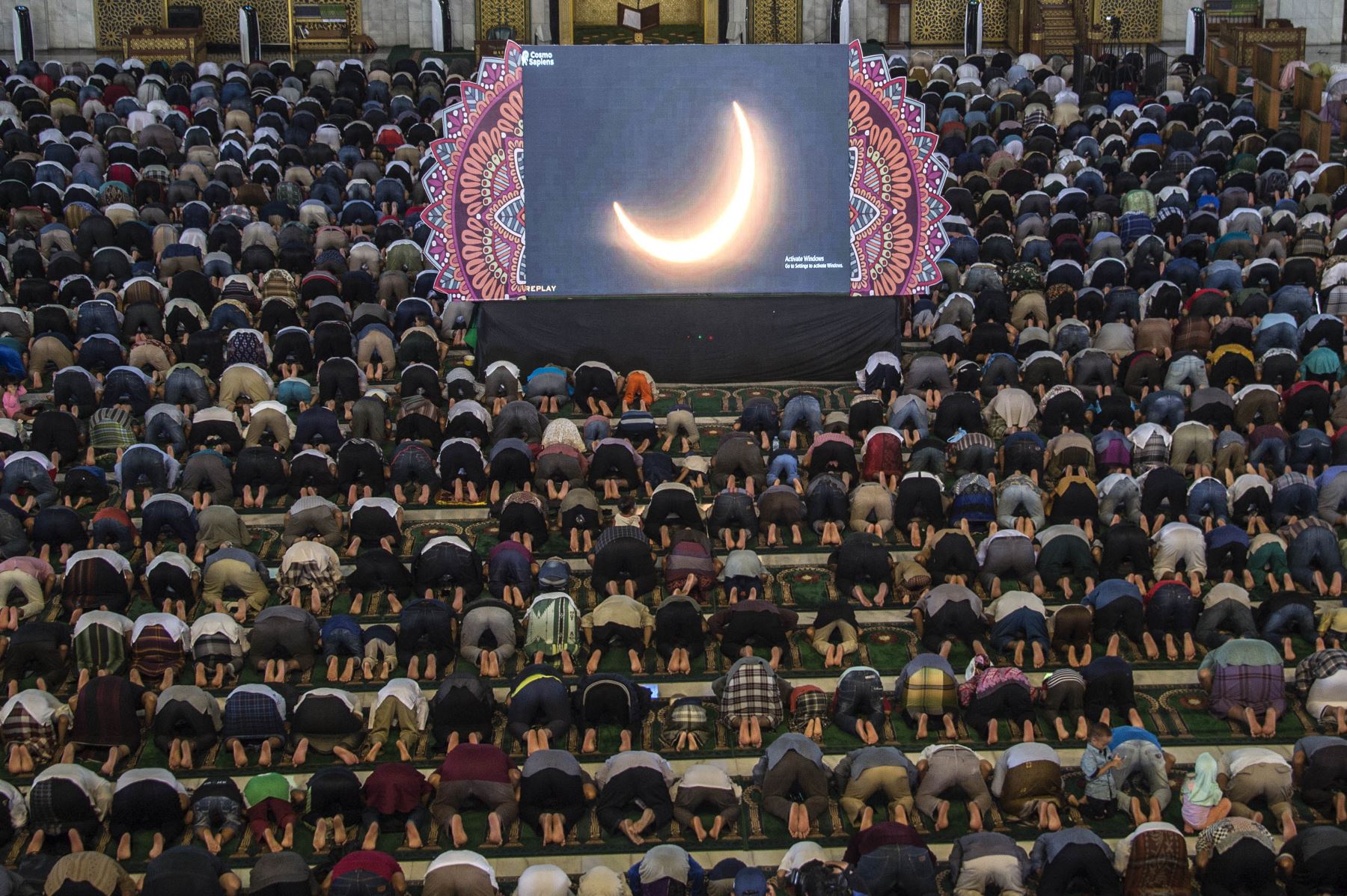 La gente reza por el eclipse solar de "anillo de fuego" en Surabaya el 26 de diciembre de 2019. Foto: AFP