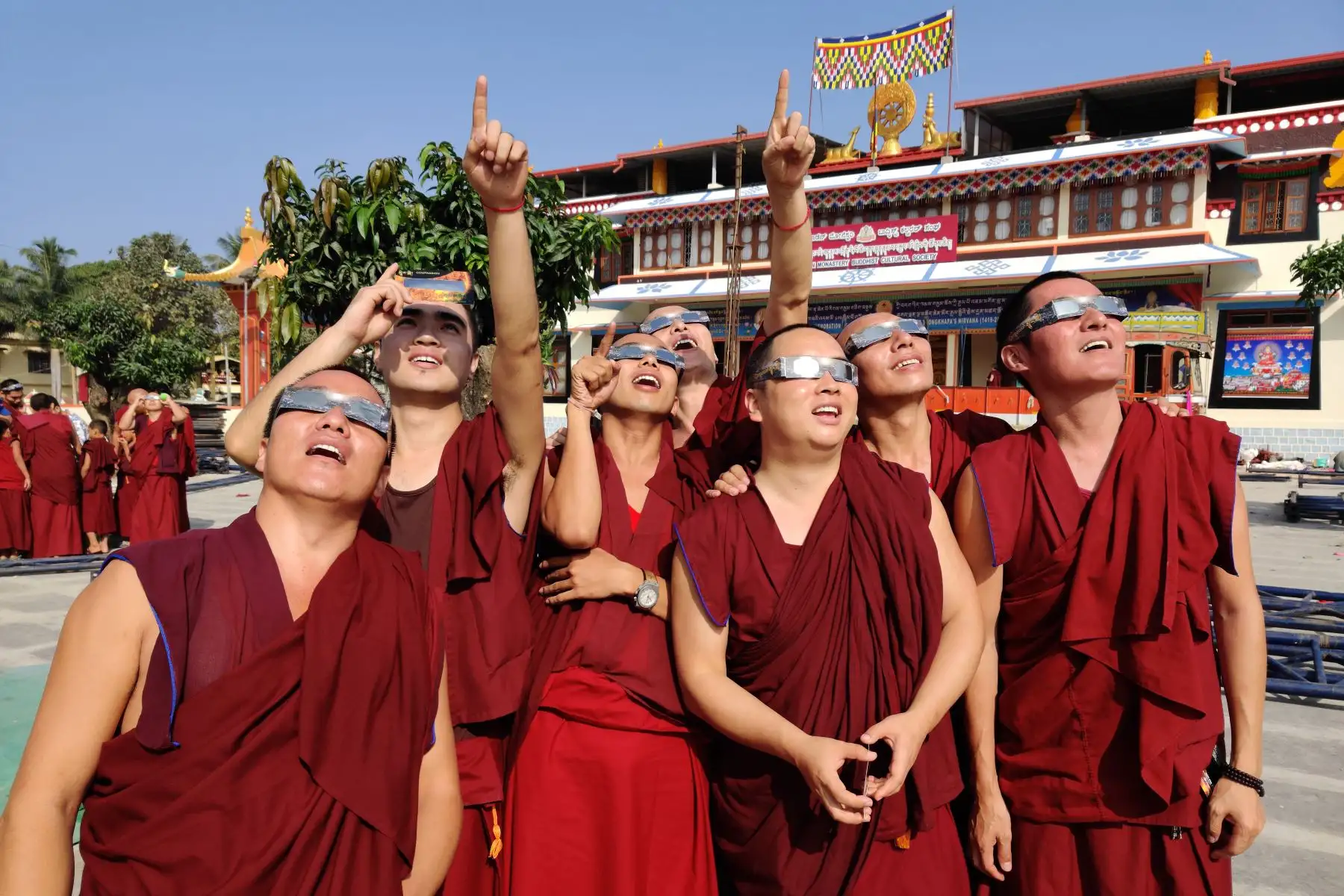 Monjes con gafas de filtro solar observan un eclipse de "anillo de fuego" en el monasterio de Gaden en una colonia tibetana en Teginkoppa, en el sur de la India. Foto: AFP