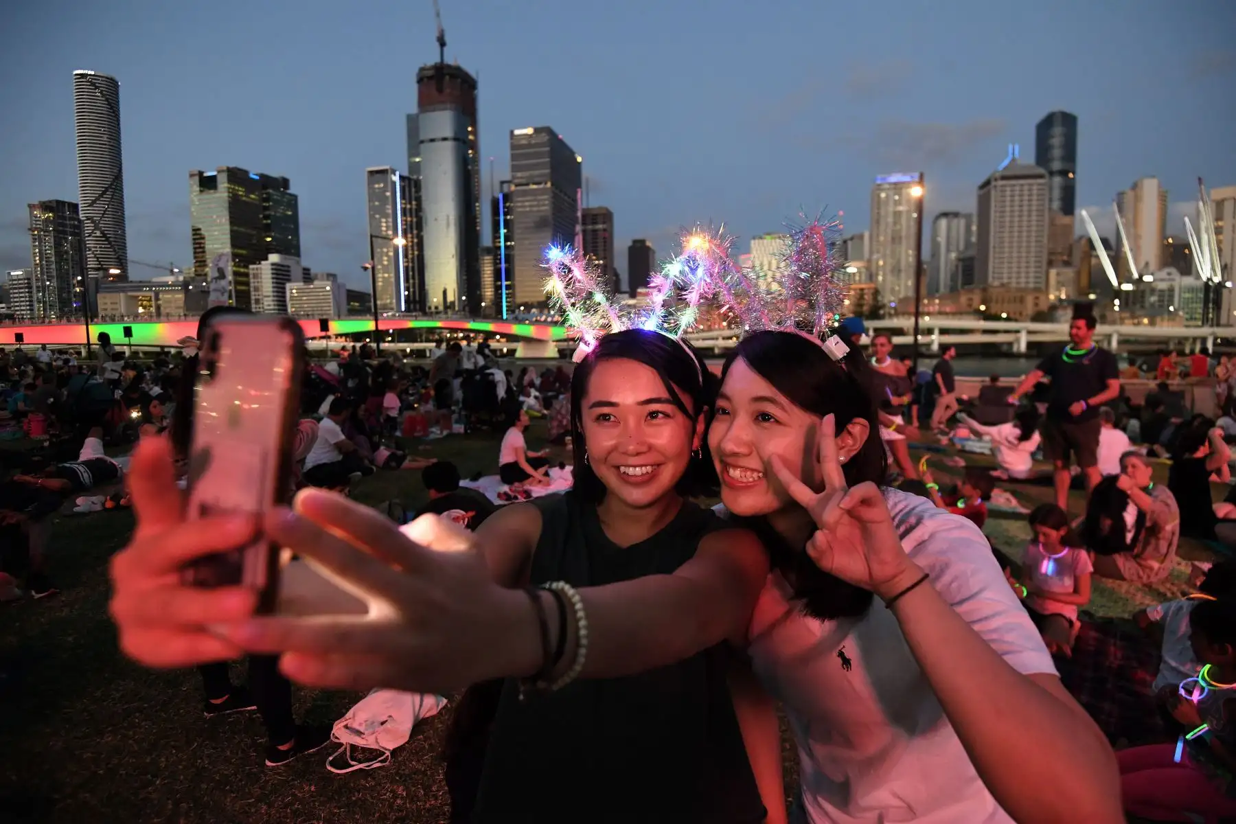 Jóvenes se toman una selfie mientras esperan ver los fuegos artificiales de Nochevieja en Southbank en Brisbane, Australia. EFE