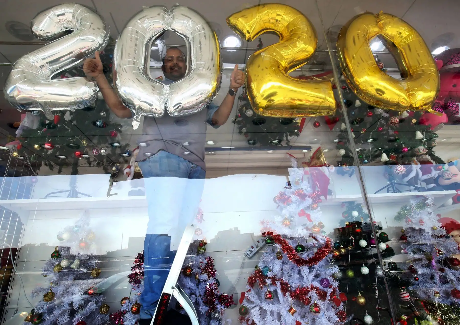 Un vendedor decora su tienda de regalos antes de la víspera de Año Nuevo en la ciudad de Kuwait. AFP
