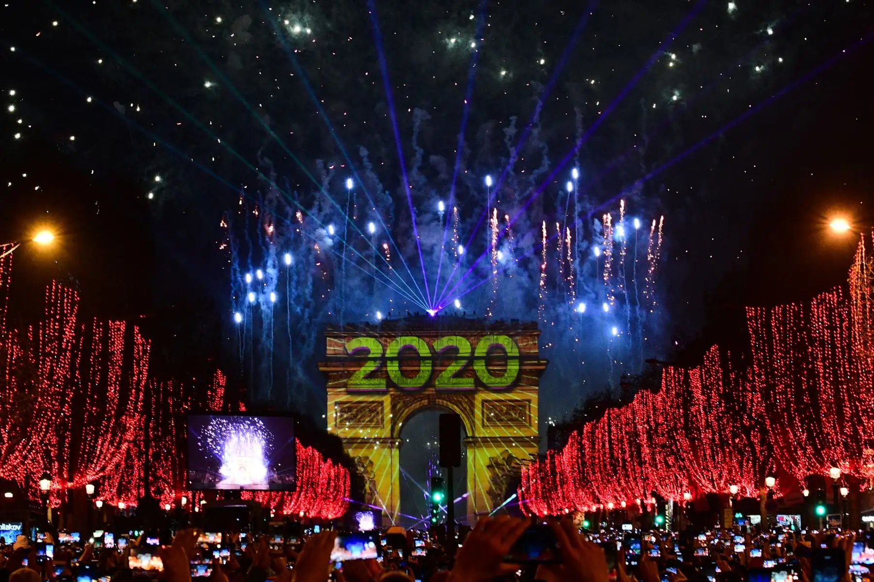La gente toma fotos de los fuegos artificiales que estallan en el cielo sobre el Arco del Triunfo durante las celebraciones de Año Nuevo en la avenida de los Campos Elíseos, en París.
Foto: AFP