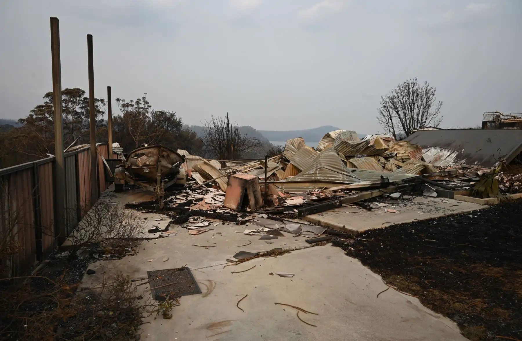 Una casa y vehículos arrasados ​​por incendios forestales se ven en la ciudad de Lake Conjola en Nueva Gales del Sur .
Foto: AFP