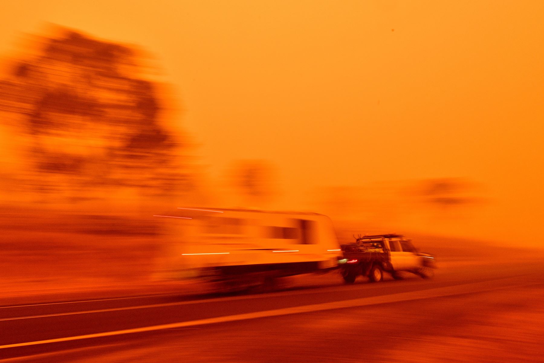 Los residentes viajan en una carretera a través del espeso humo de los incendios forestales en Bemboka, en el estado australiano de Nueva Gales.
Foto: AFP