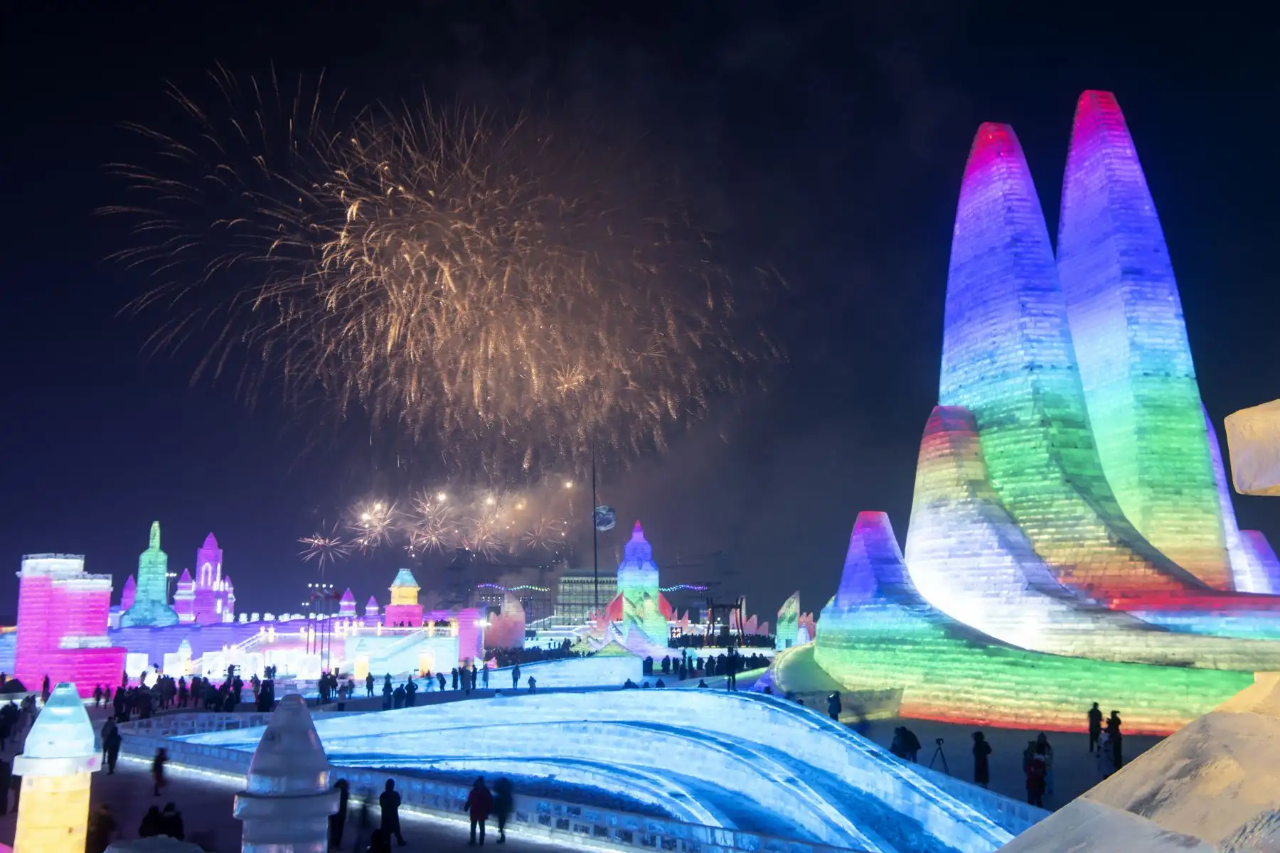 Turistas observan el espectáculo de fuegos artificiales durante el Festival Internacional de Hielo y Nieve de Harbin en China. Foto: AFP