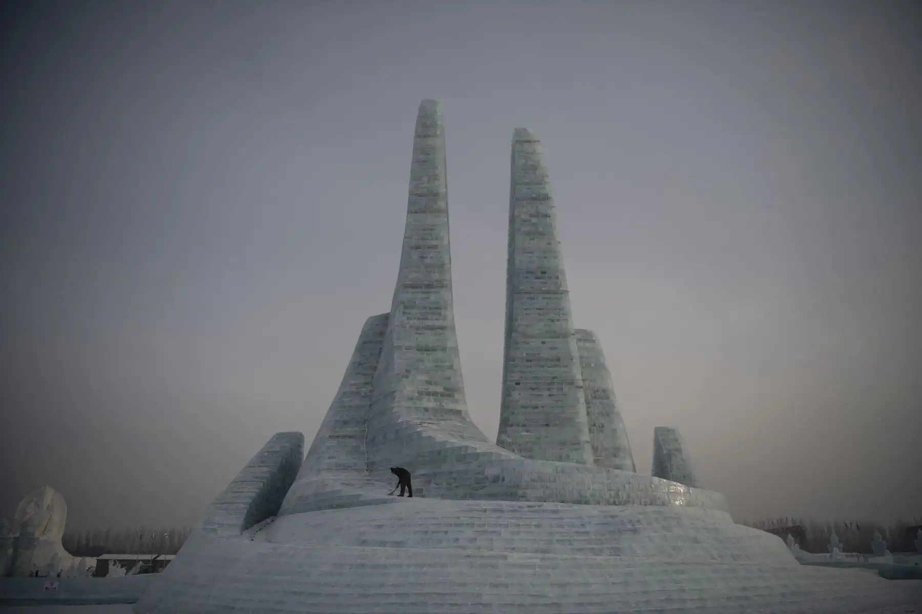 Trabajadores limpian la nieve durante el Festival Internacional de Hielo y Nieve de Harbin en China. Foto: AFP