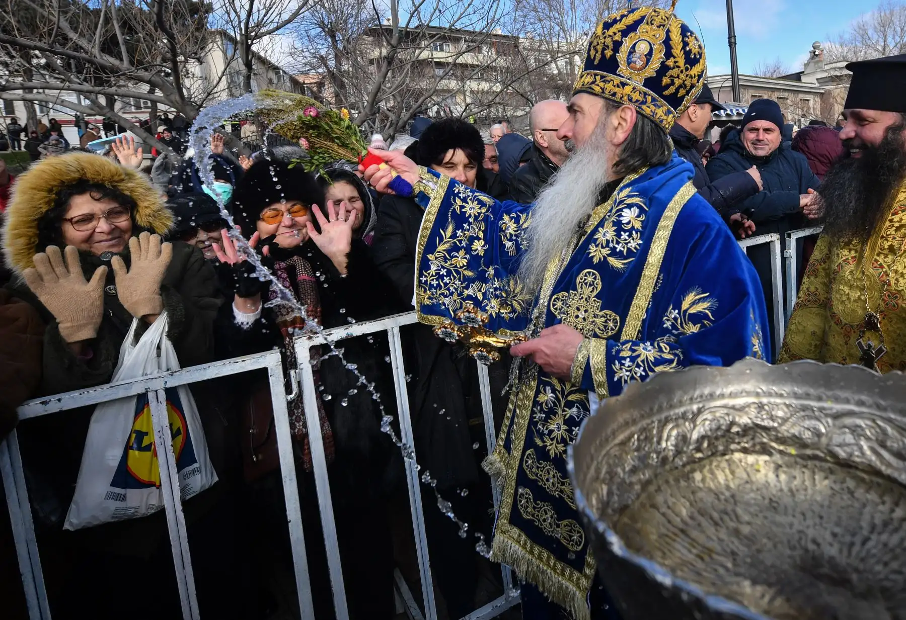 Los creyentes ortodoxos rumanos son bendecidos con agua bendita por un sumo sacerdote ortodoxo en el Mar Negro durante la celebración de la Epifanía en la ciudad de Constanta.
Foto: AFP