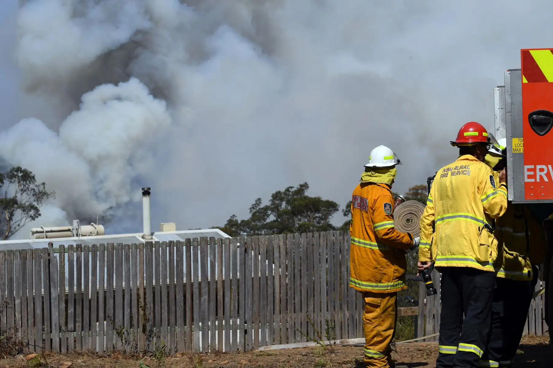 Bomberos trabajan mientras el humo se eleva de un incendio forestal en Penrose, en el estado australiano de Nueva Gales del Sur. Foto: AFP