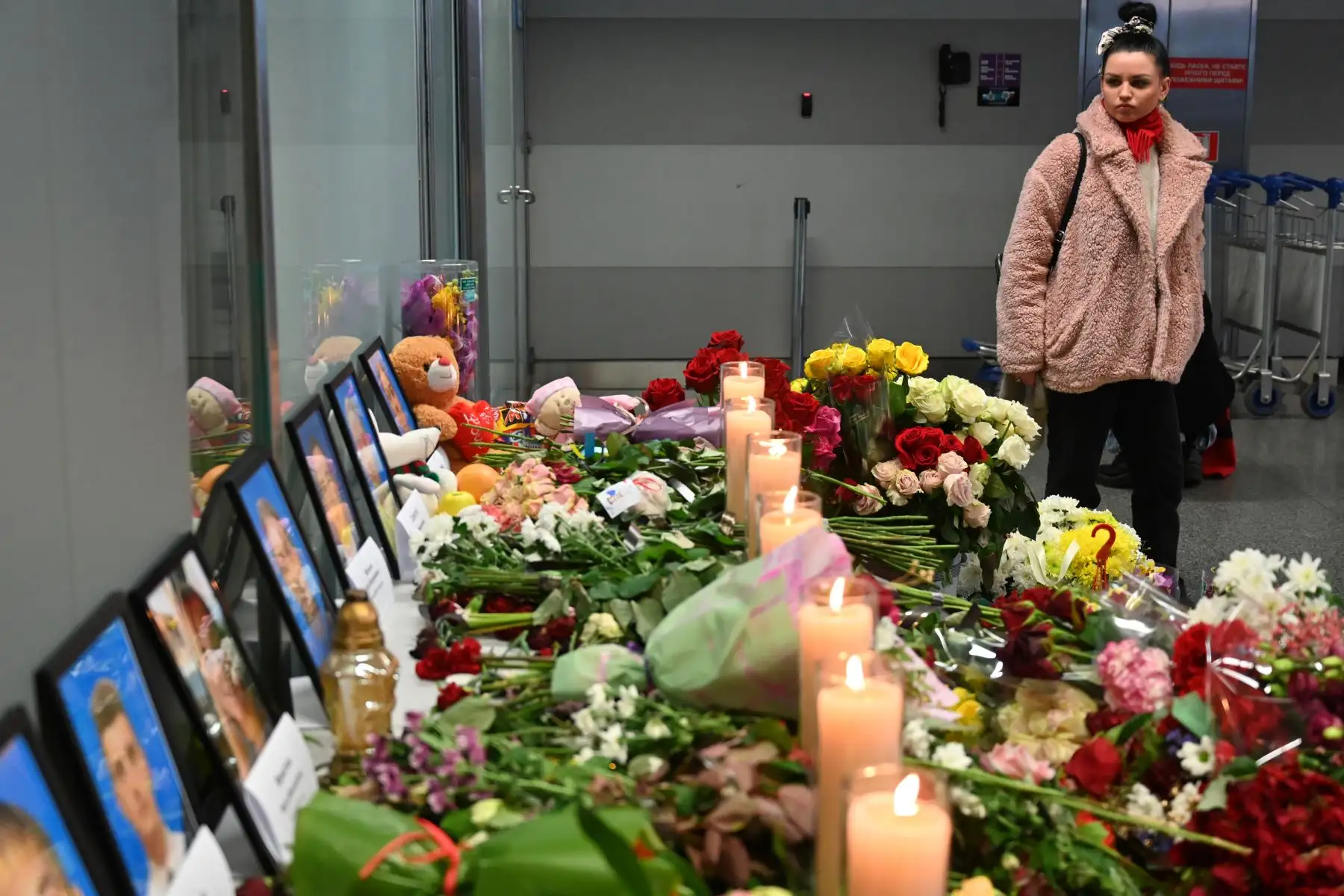 Una mujer se para frente a un monumento improvisado en el aeropuerto Boryspil a las afueras de Kiev, el 11 de enero de 2020, mientras rinde homenaje a las víctimas del Boeing 737-800 de Ukraine International Airlines que se estrelló cerca de la capital iraní, Teherán. 
Foto: AFP